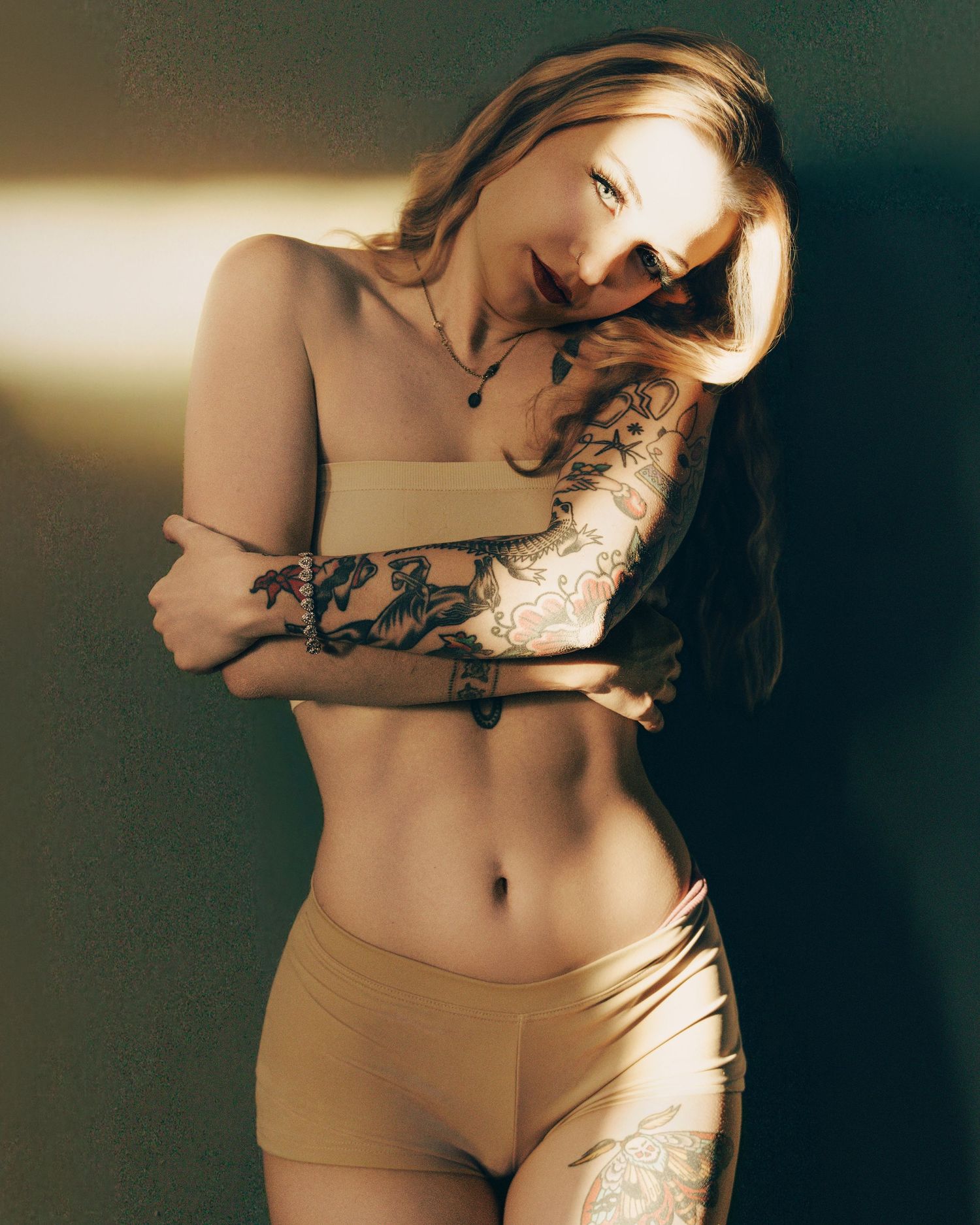 A moody boudoir photoshoot with artistic lighting and shadows creating an intimate atmosphere.