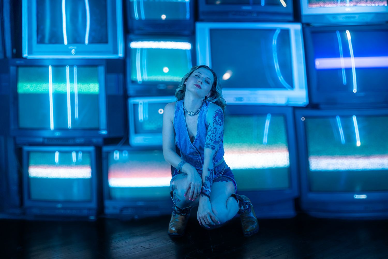 Person moves through a cyberpunk-inspired hallway with glowing blue neon lights and digital displays.