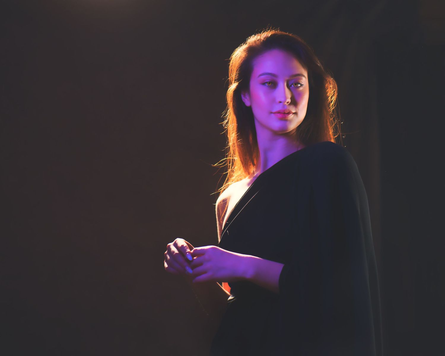 A dramatic series of profile shots illuminated by purple lighting shows a figure emerging from darkness.