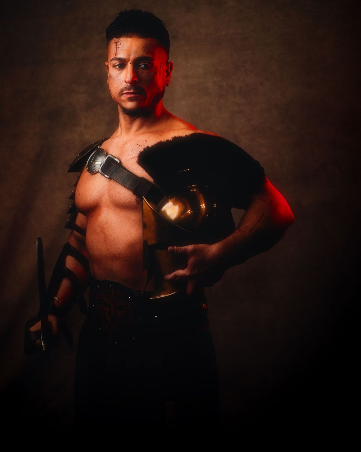 Dramatic portrait with carved sculpture armor and red lighting against dark textured background.