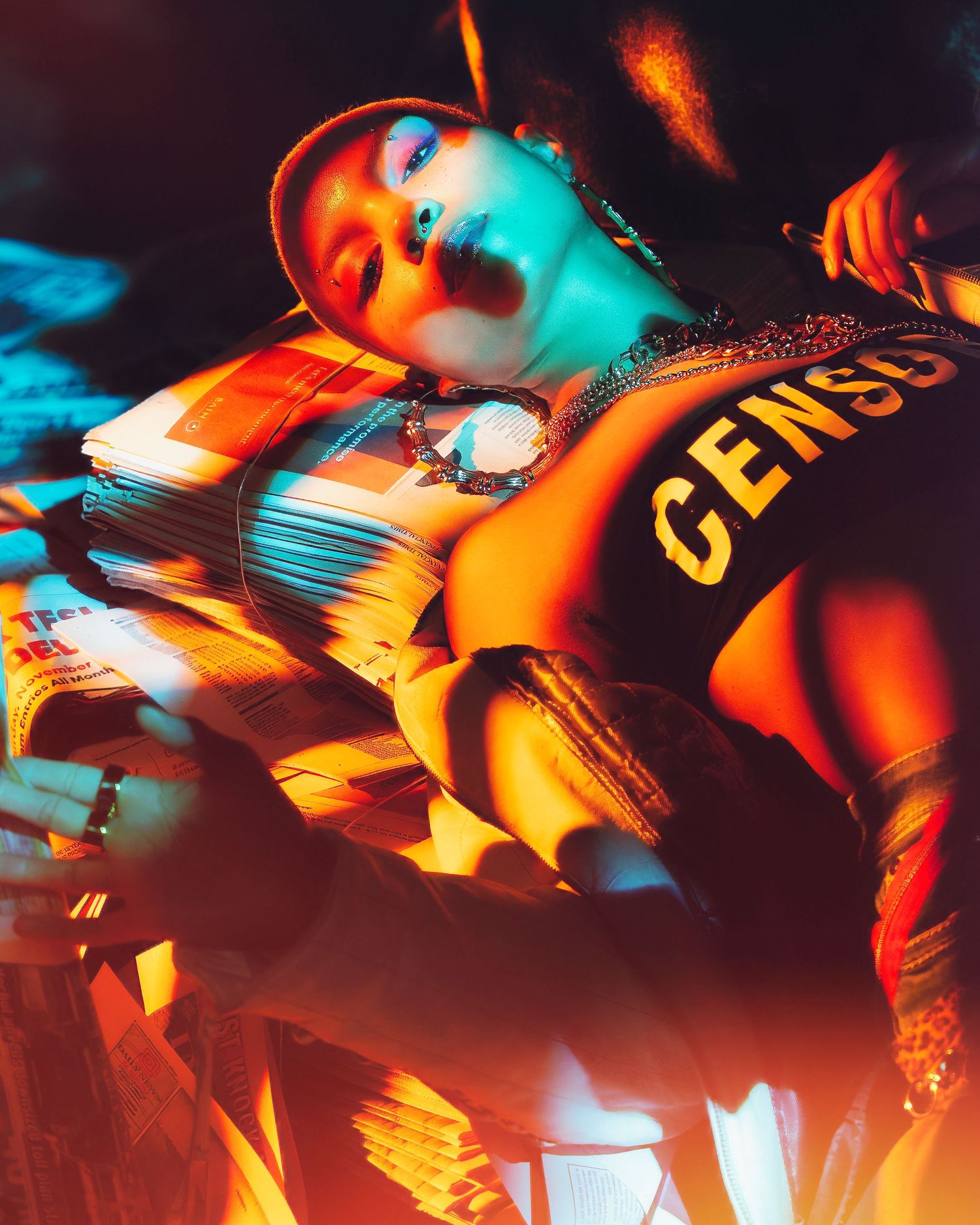 Artistic portrait with dramatic orange and teal lighting against dark background featuring Genesis text on clothing.