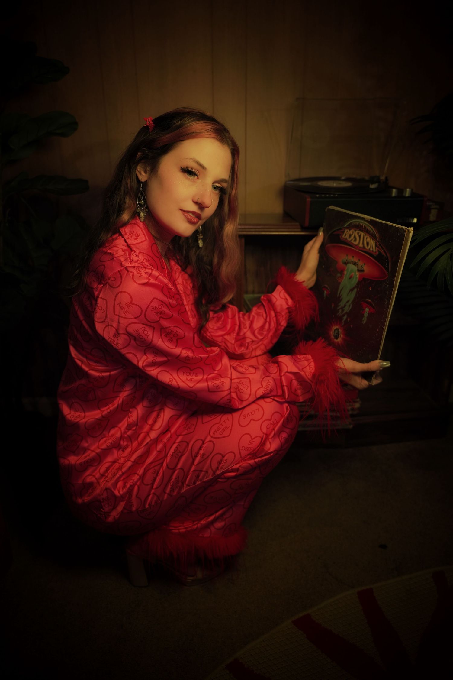 A person in a flowing red dress poses dramatically against a dark background in an artistic photo series.