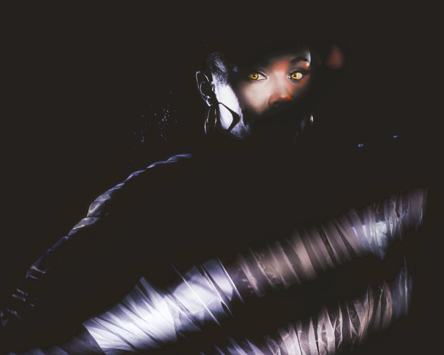 A dramatic dark portrait with light illuminating piano keys in shadow.
