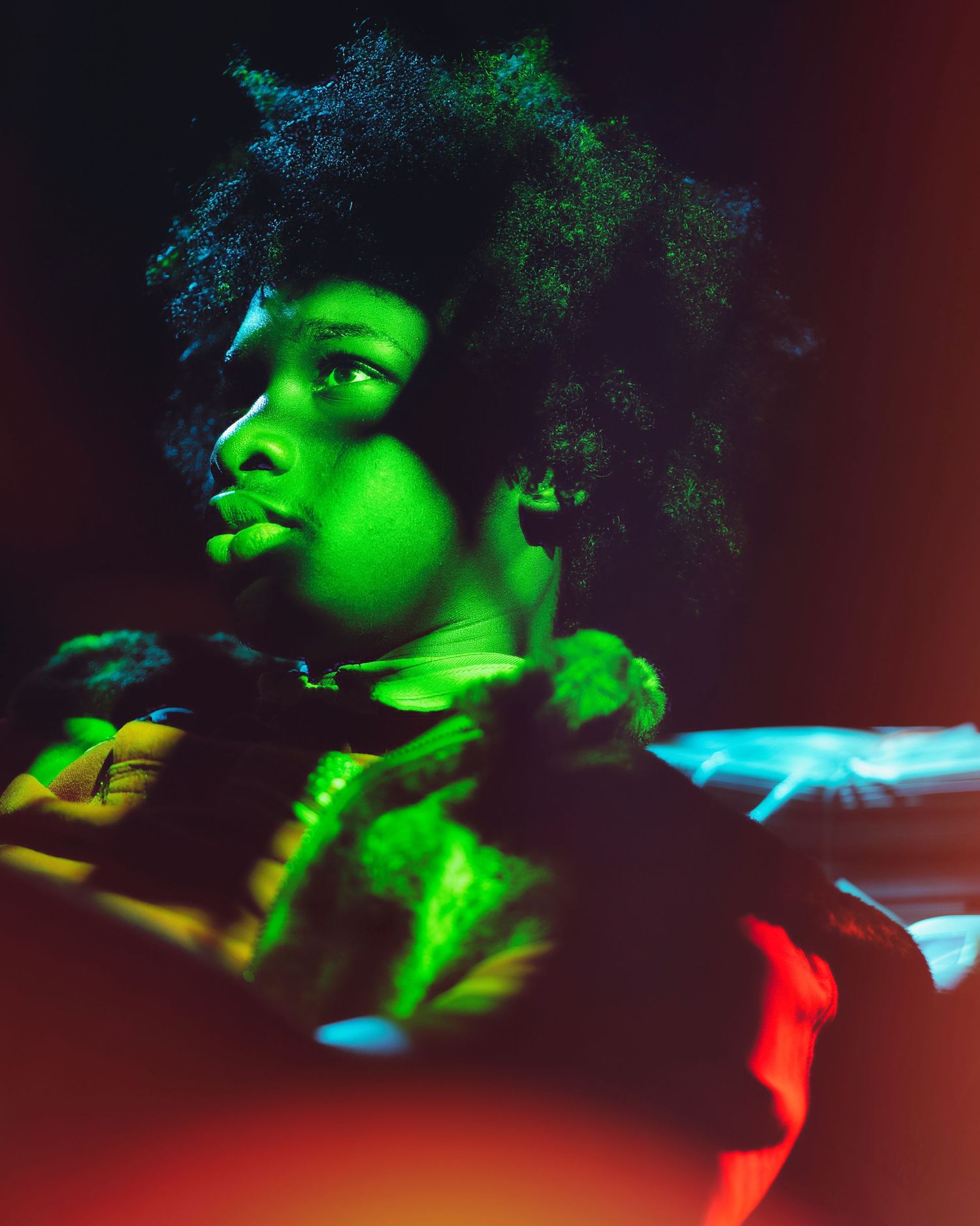 A series of artistic portraits with green and red lighting effects creating a dramatic silhouette against a dark background.