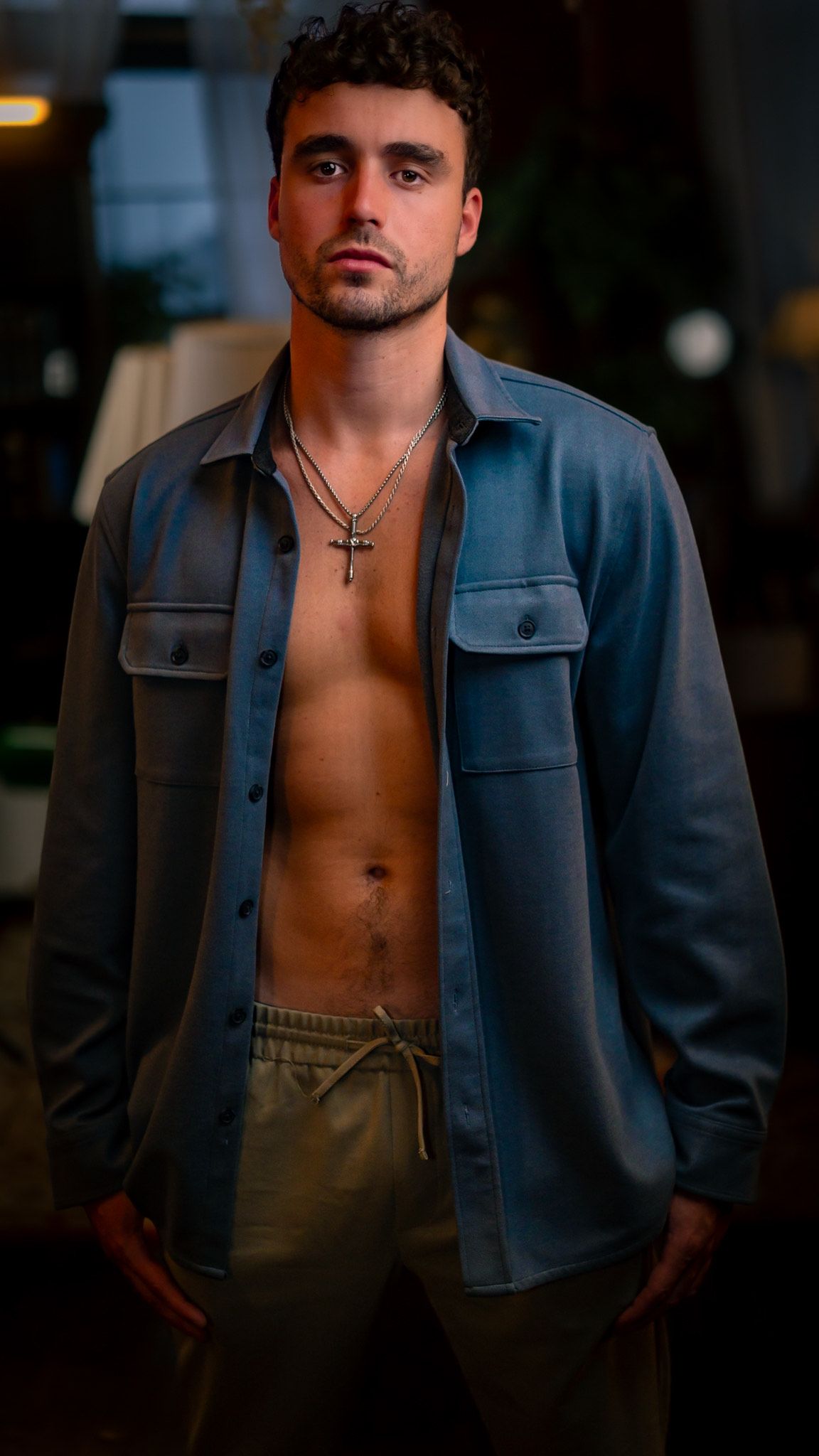 A moody portrait series showing a person in an open denim jacket and dress pants against a dark background.