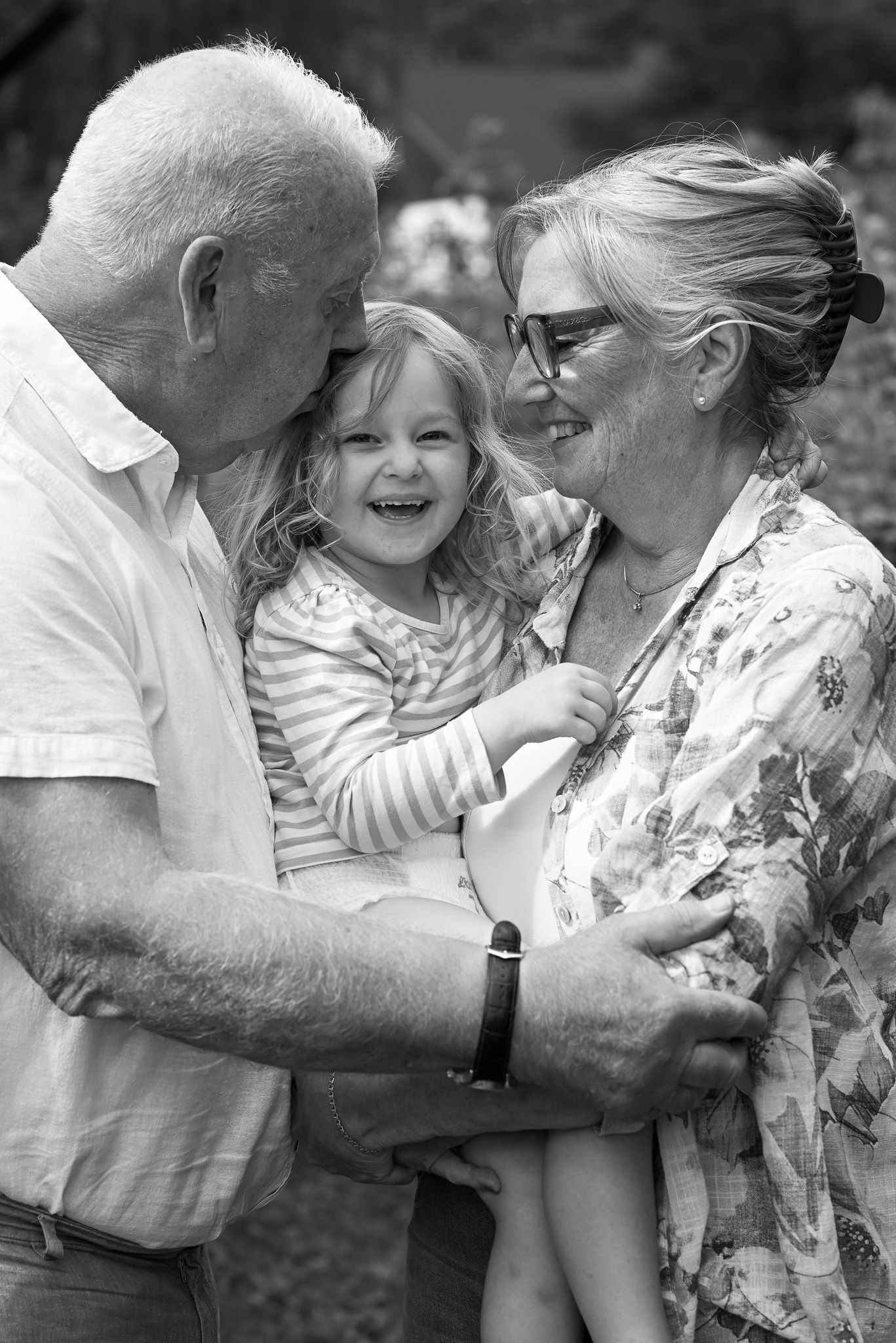 Svartvitt foto som visar på kärleken i familjen under en generationsfotografering.