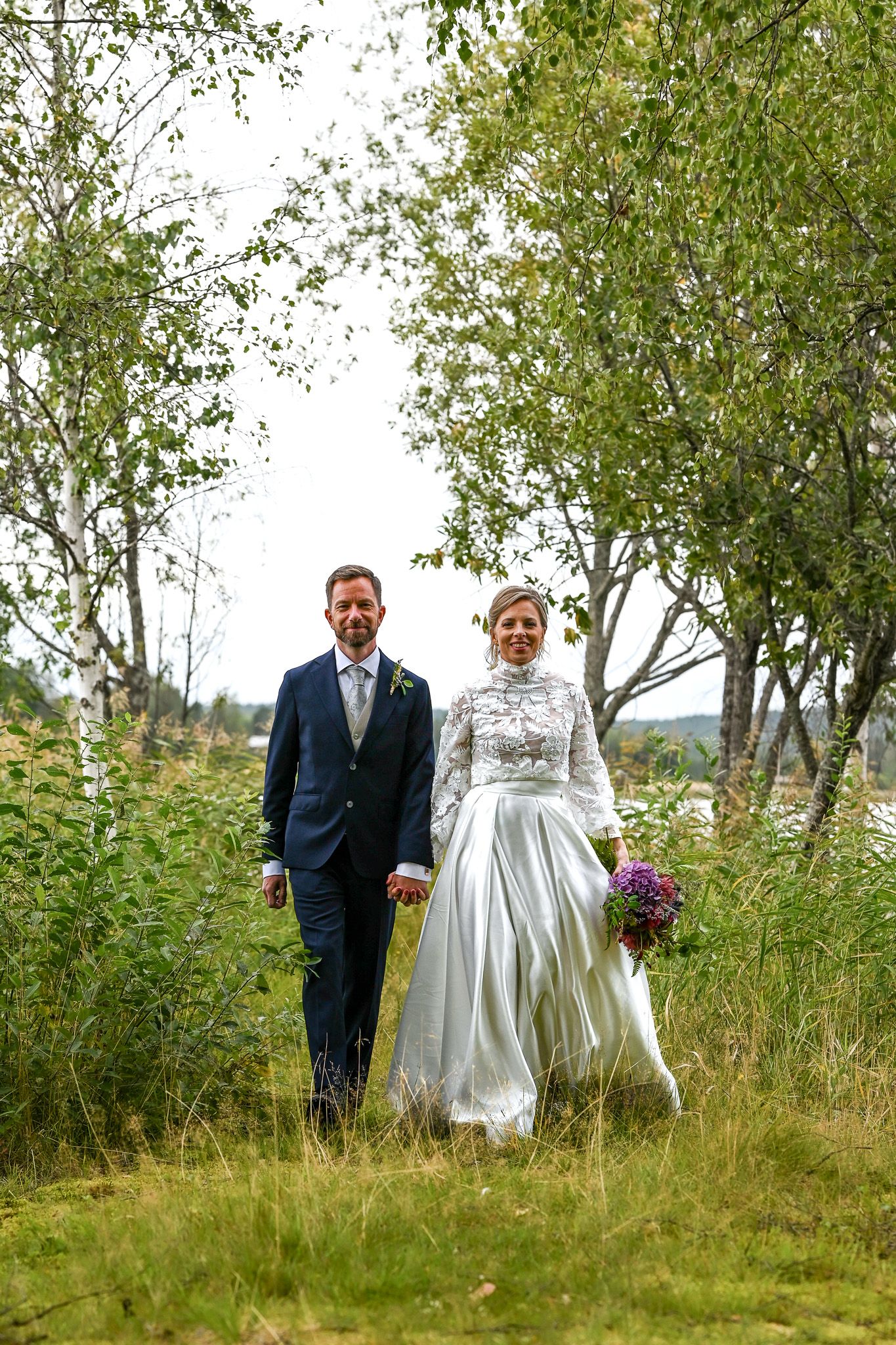 Brudpar i naturligt landskap under bröllopsporträtt.