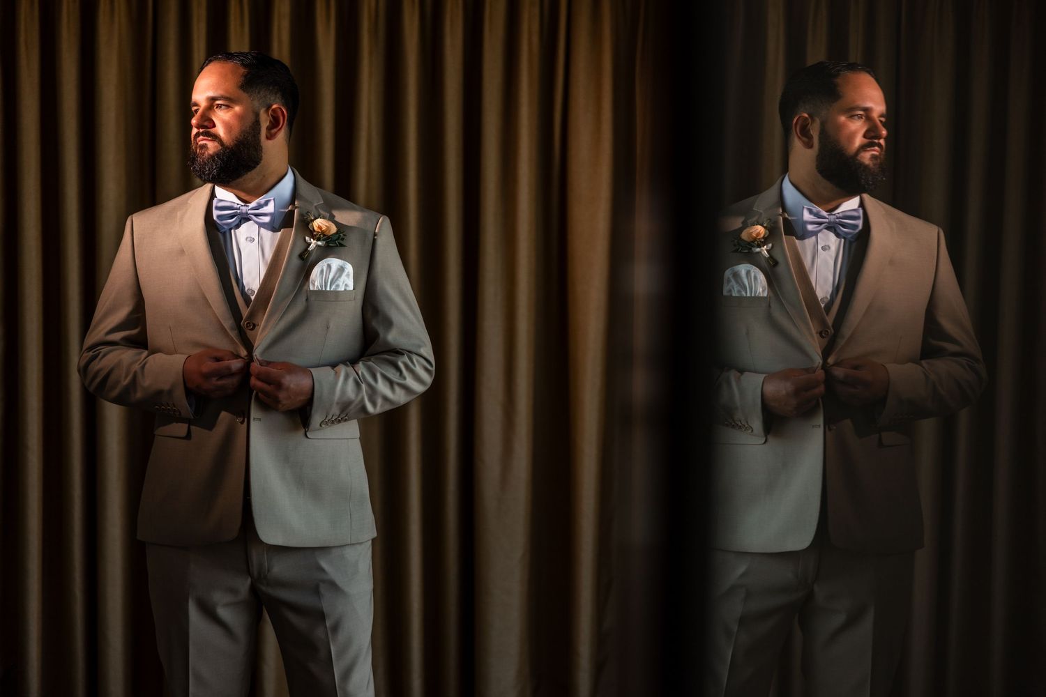A dapper groom in a gray suit and bow tie adjusts his jacket, reflected in a mirror against a brown curtain backdrop.