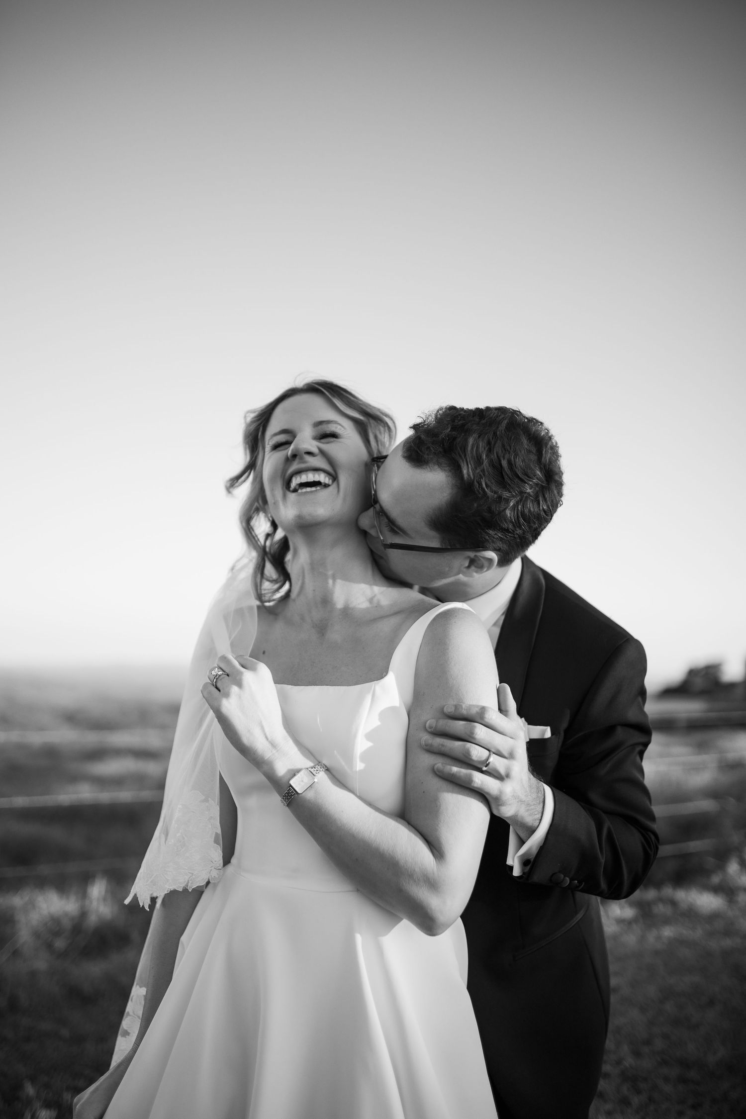 Joyful couple shares tender moments in elegant black and white wedding photography series.