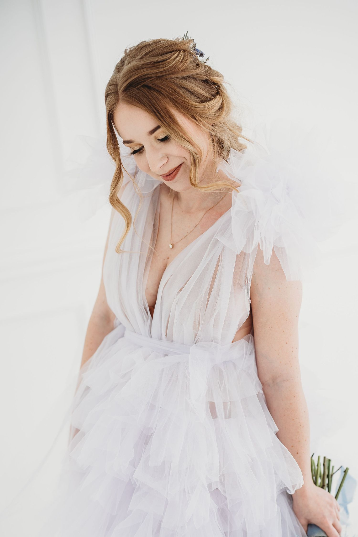 Romantic bridal portrait in a delicate white tulle gown with plunging neckline.