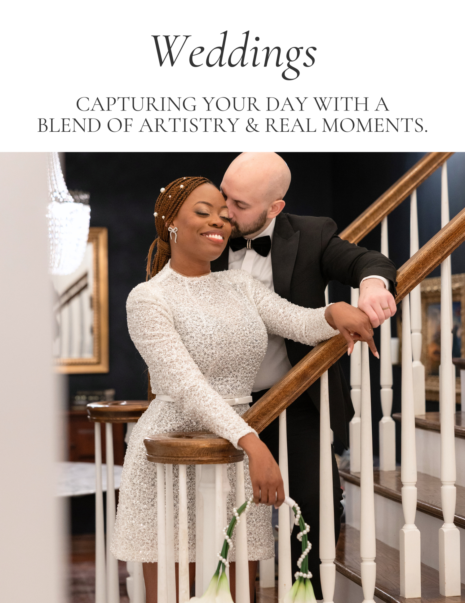 A joyful interracial couple poses on a staircase, bride in white lace dress, groom in tuxedo, wedding photography advertisement.
