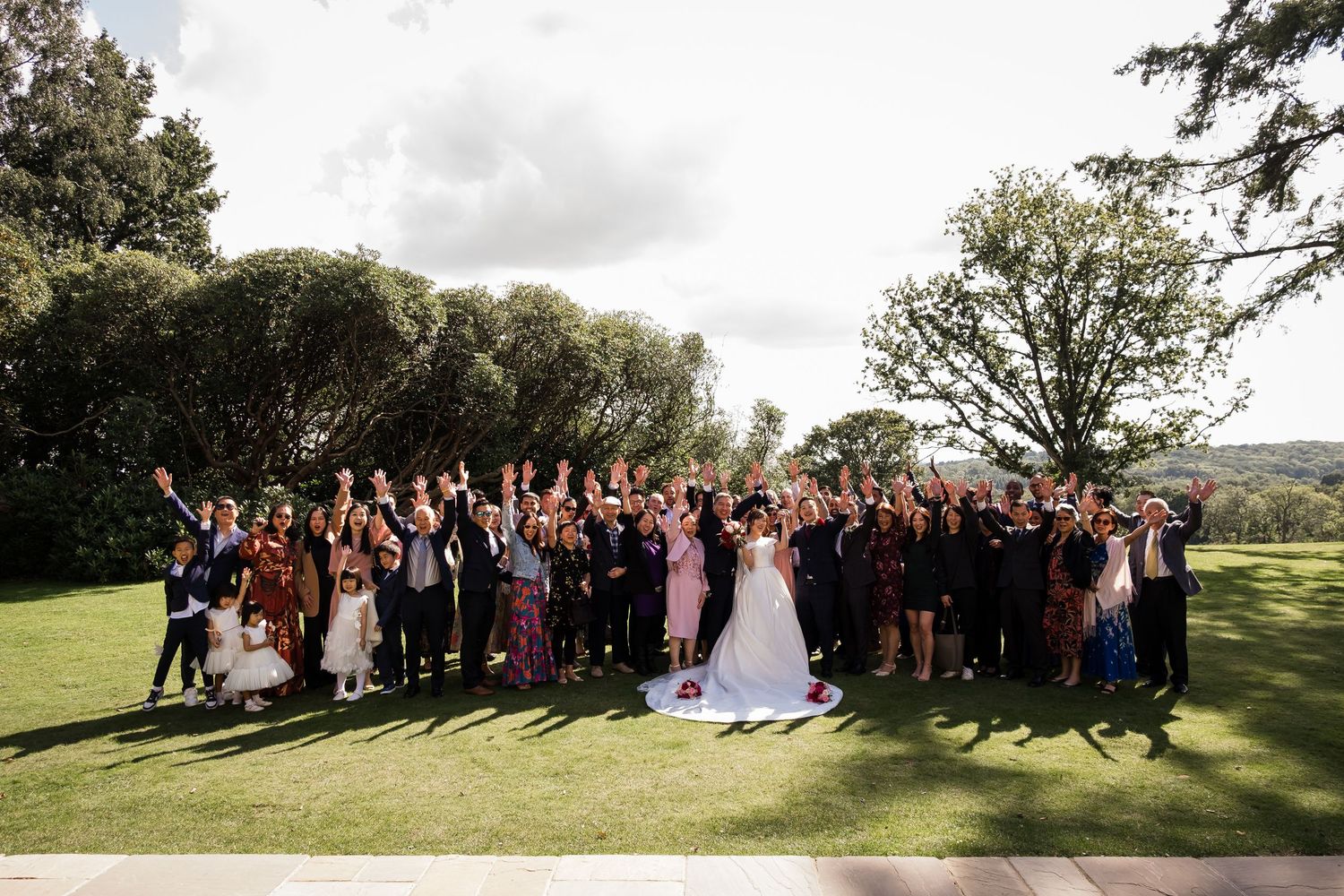 Large group wedding photo with all guests outside Highley Manor in Sussex.