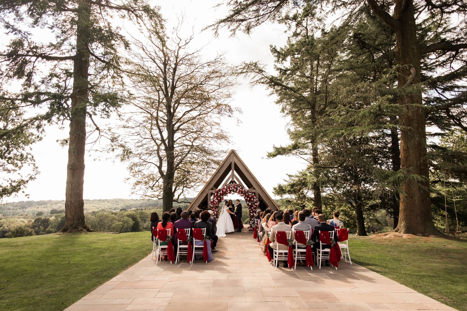 Panoramic collage of a rustic outdoor wedding ceremony with guests seated among tall pine trees at sunset.