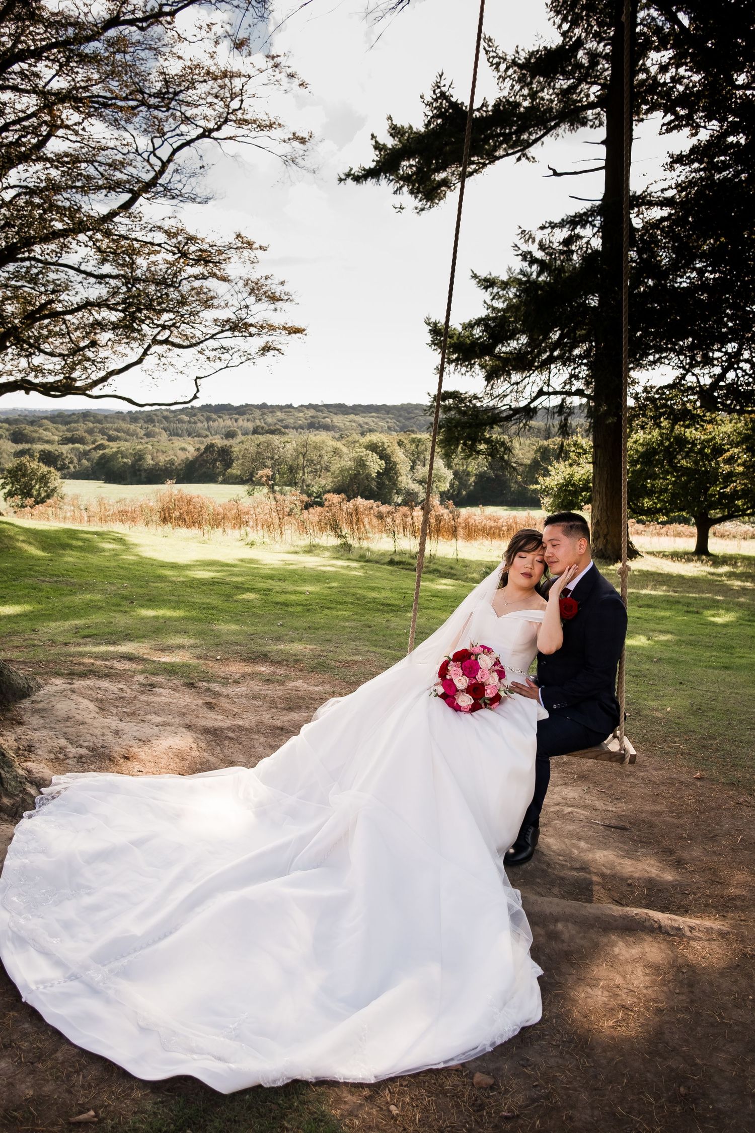 A romantic wedding photo series shows a couple in formal attire sitting on a tree swing in a scenic outdoor setting.