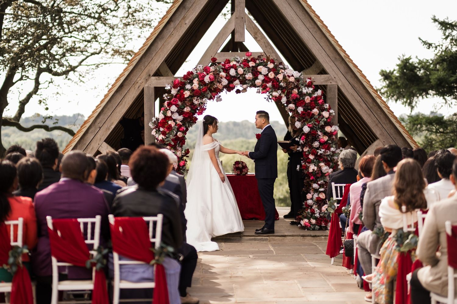 Wedding ceremony at Highley Manor featuring red décor inspired by Chinese heritage.