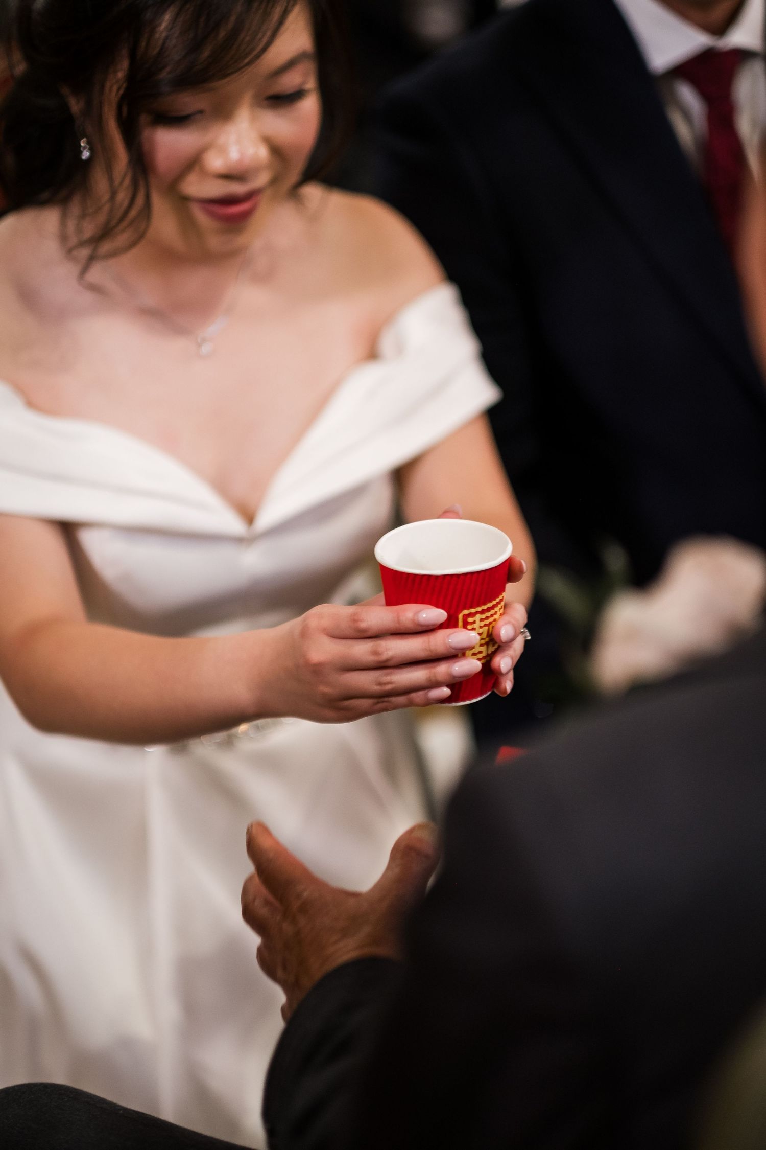 Bride and groom serving tea to family during a Chinese wedding tea ceremony.