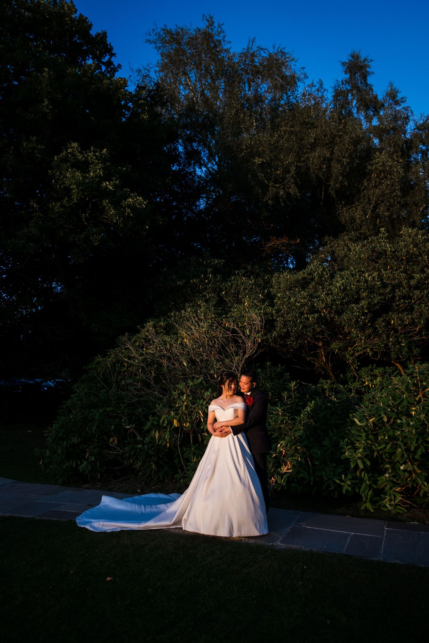 Bride and groom walking through the gardens at Highley Manor during golden hour.