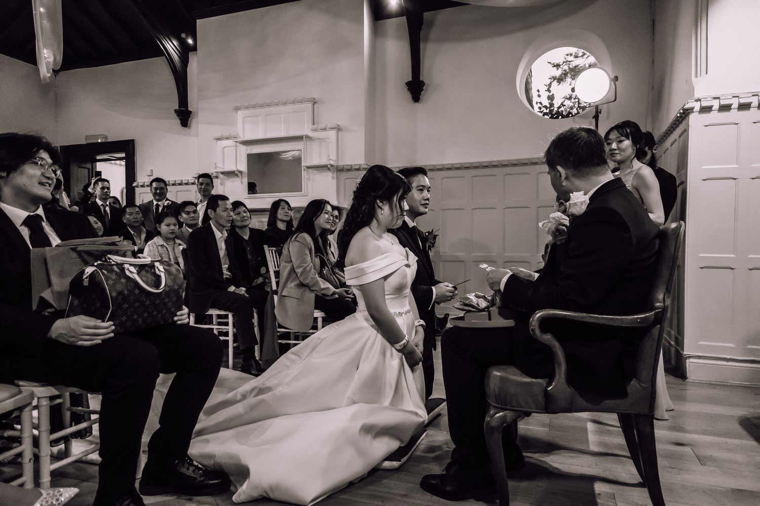 A couple performs a graceful dance lift during a wedding reception with guests watching in the background.