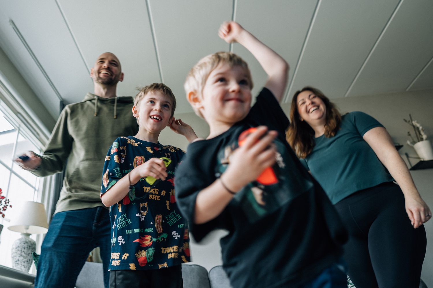Familjen står tillsamman och spelar ett tv-spel.