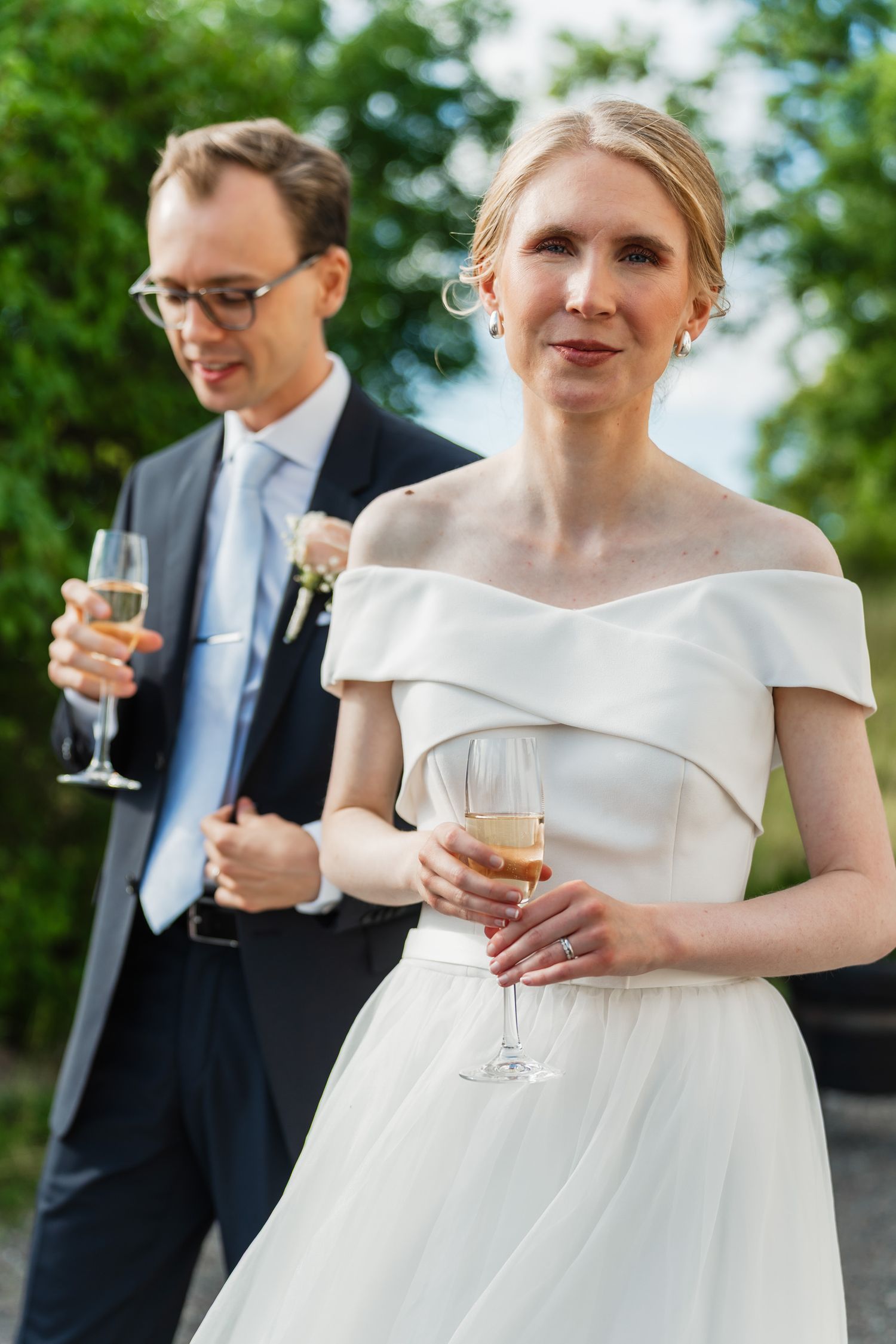 Brudparet under minglet med champagne i handen.