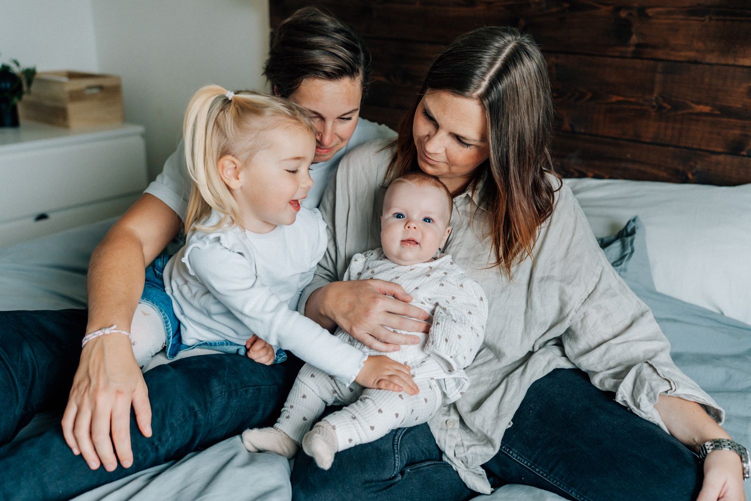 Familjen samlas runt den nyfödda bebisen under familjefotograferingen i Linköping.