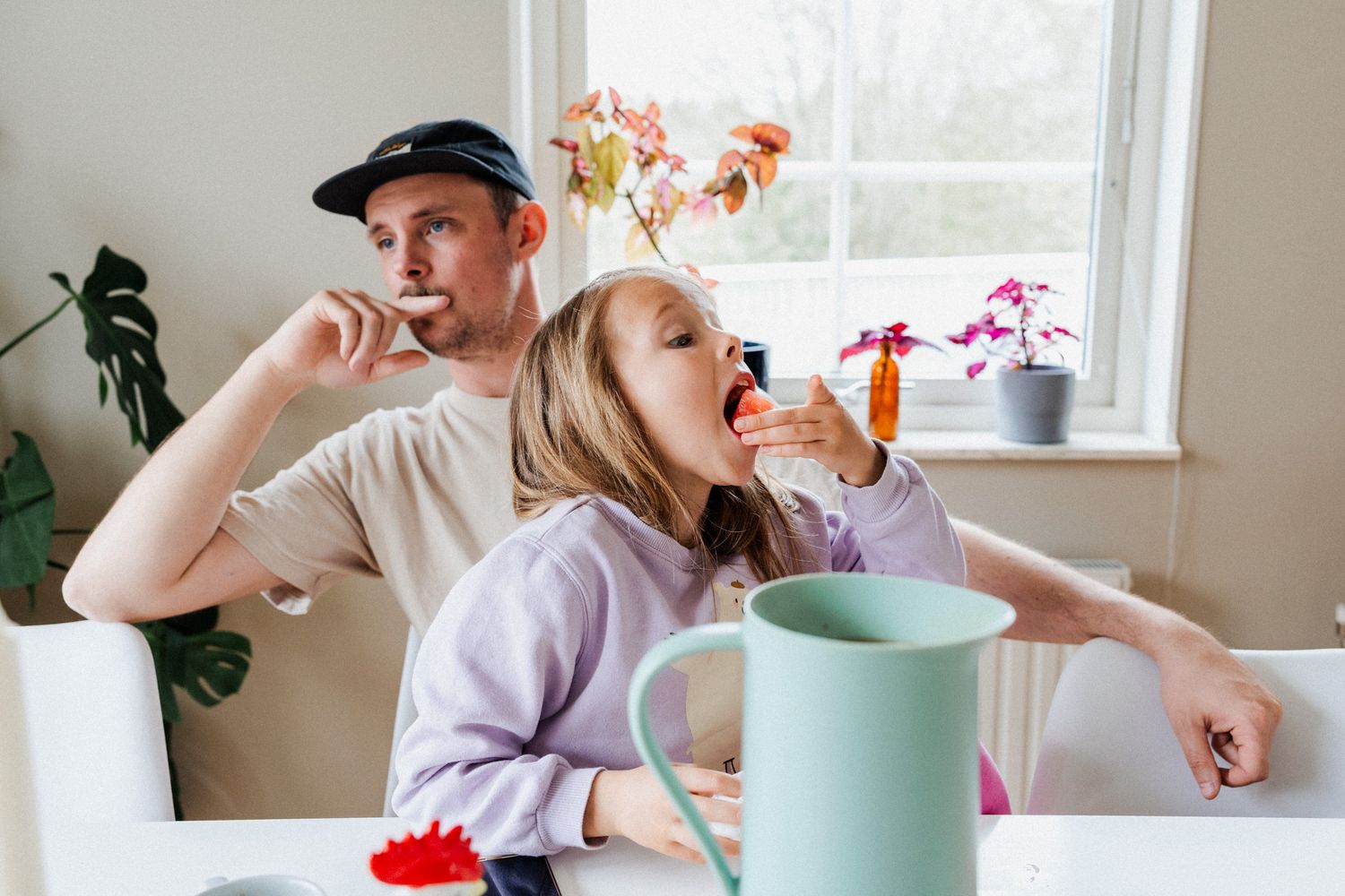 En pappa har sitt barn i knät och de är vända åt olika håll.