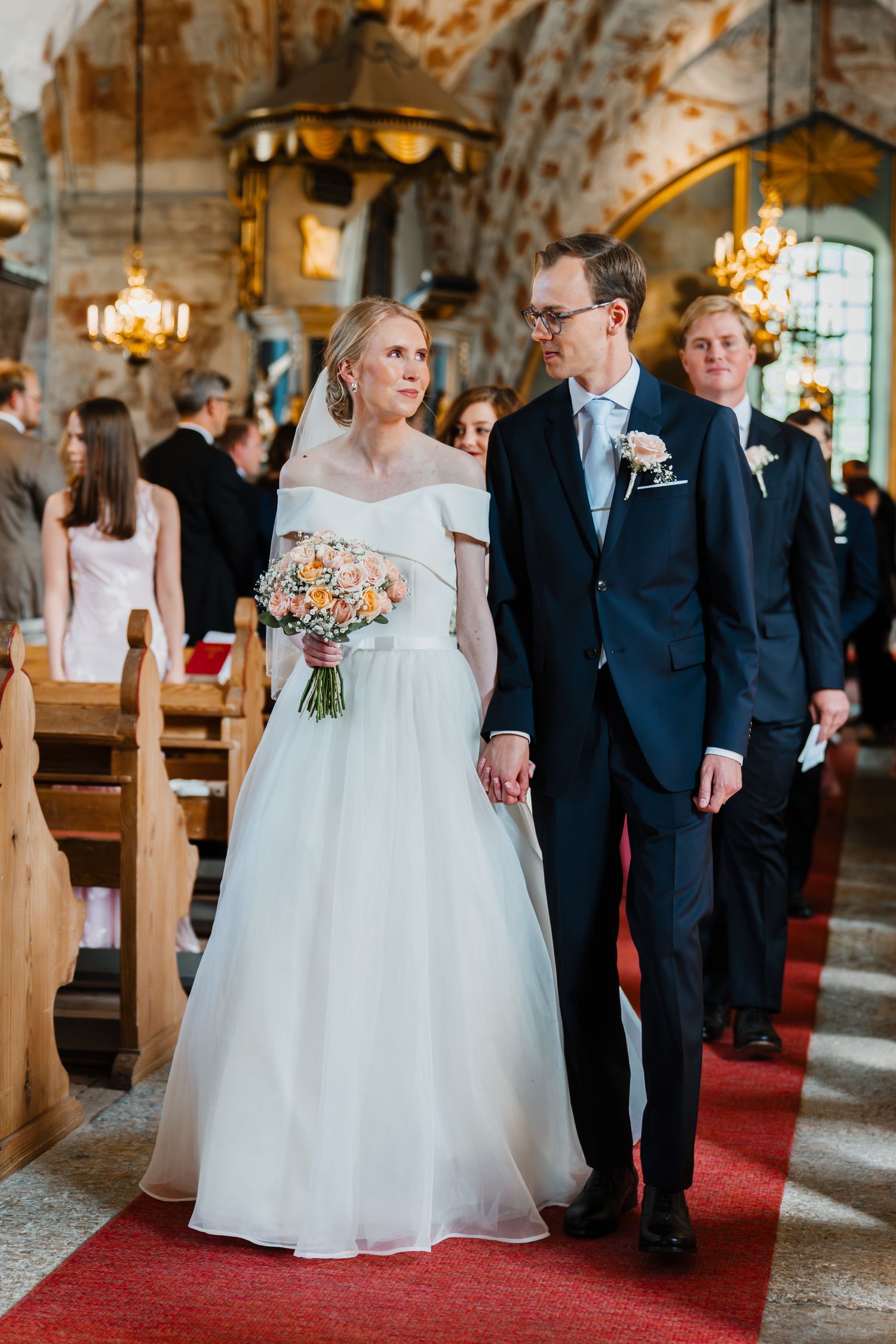 Brudparet går ut ur kyrkan hand i hand.