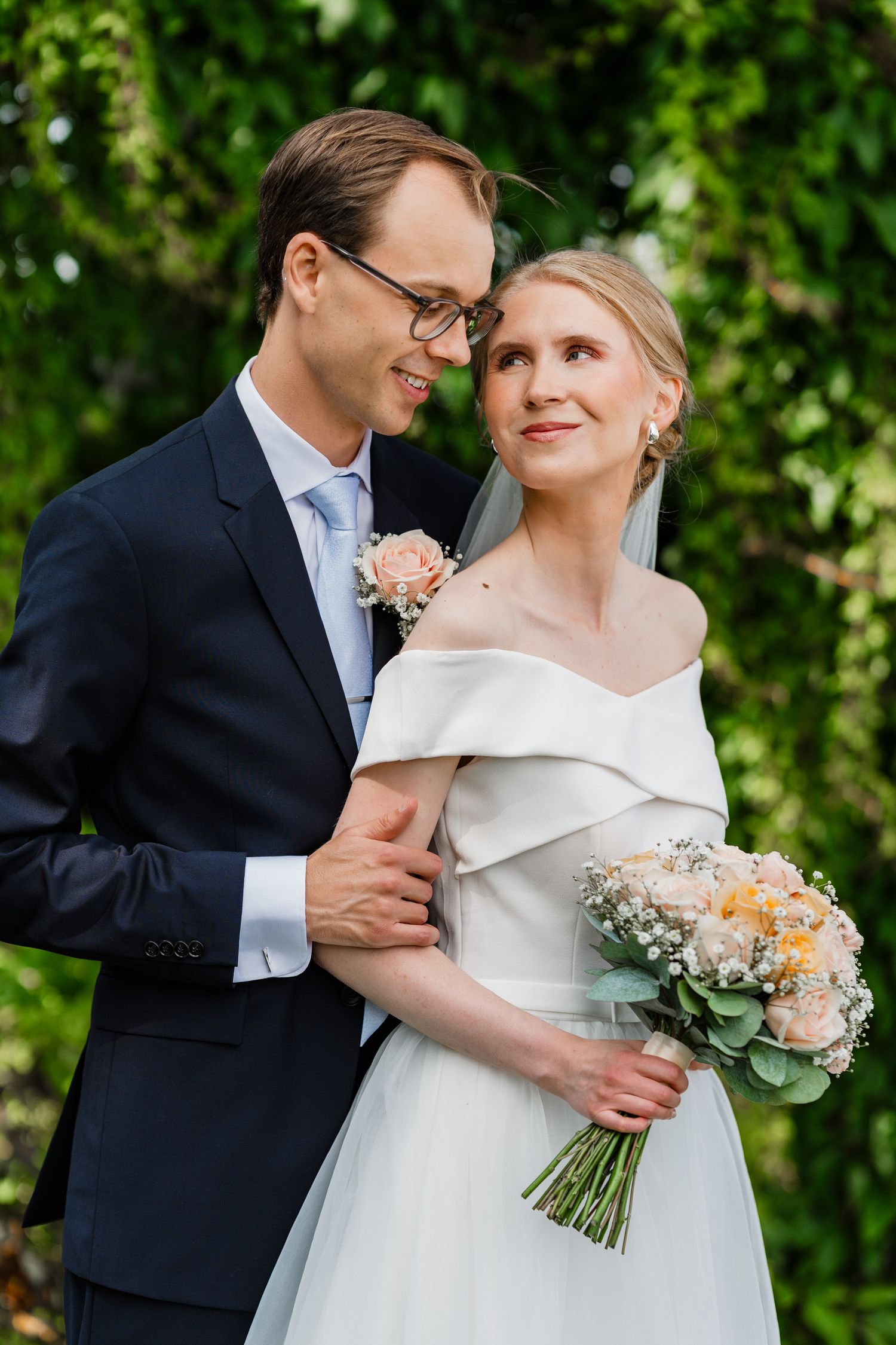 Brudparet håller om varandra under bröllopsfotograferingen i Linköping