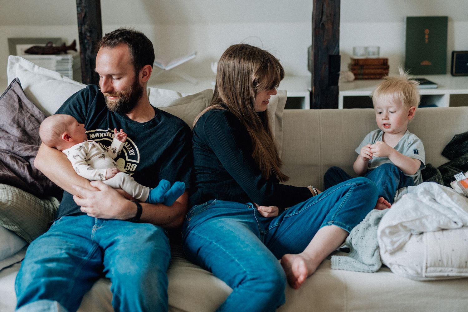 Familjen sitter i soffan och är fokuserade på varandra.