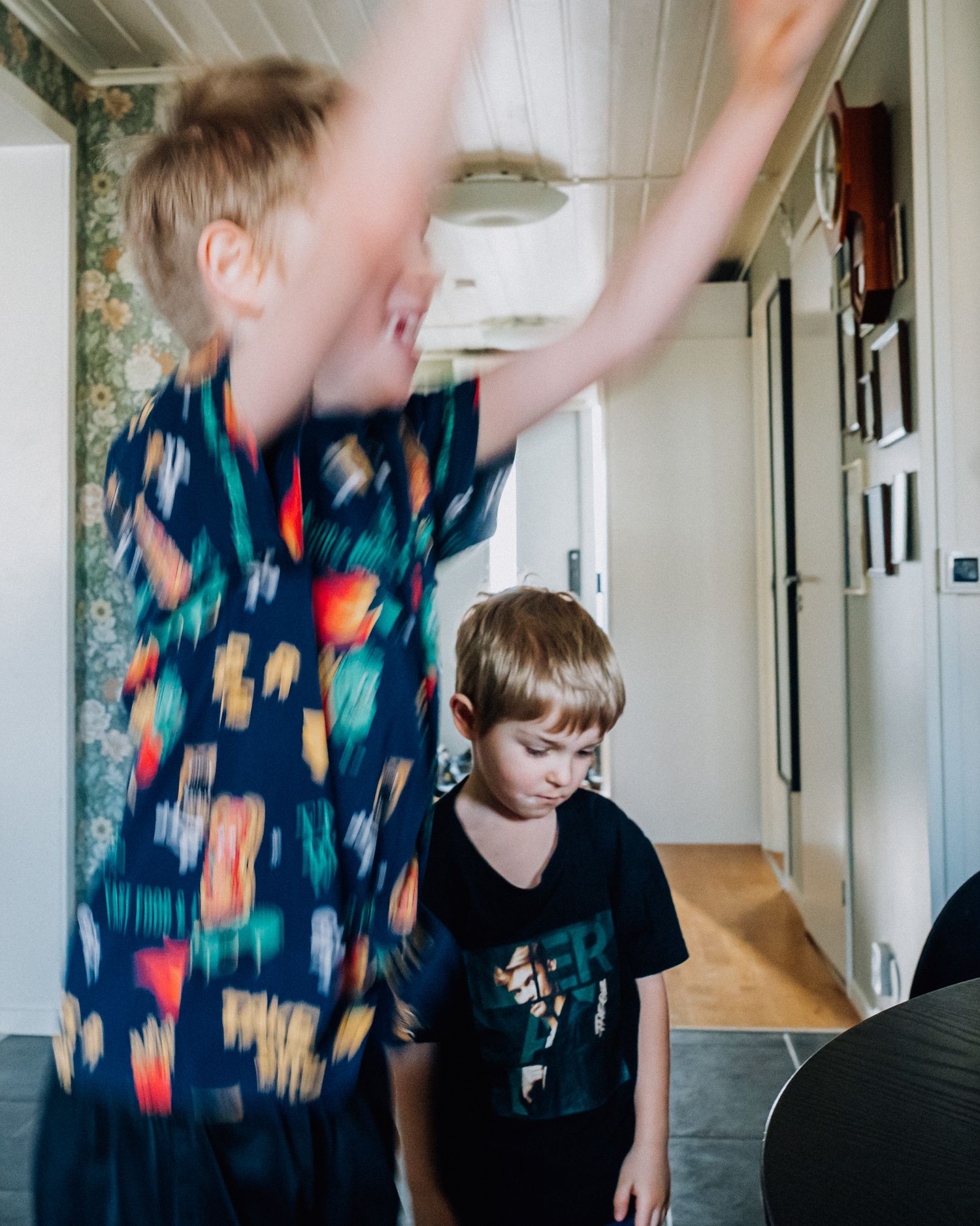 Två pojkar i ett hem - en hoppas och ler och den andra ser ledsen ut.