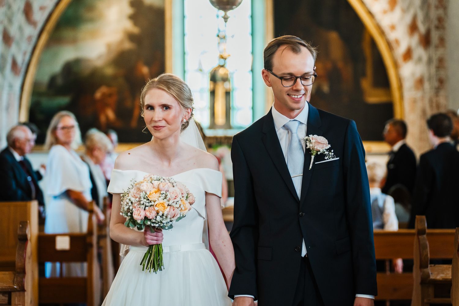 Brudparet är lyckliga på väg ut från kyrkan.