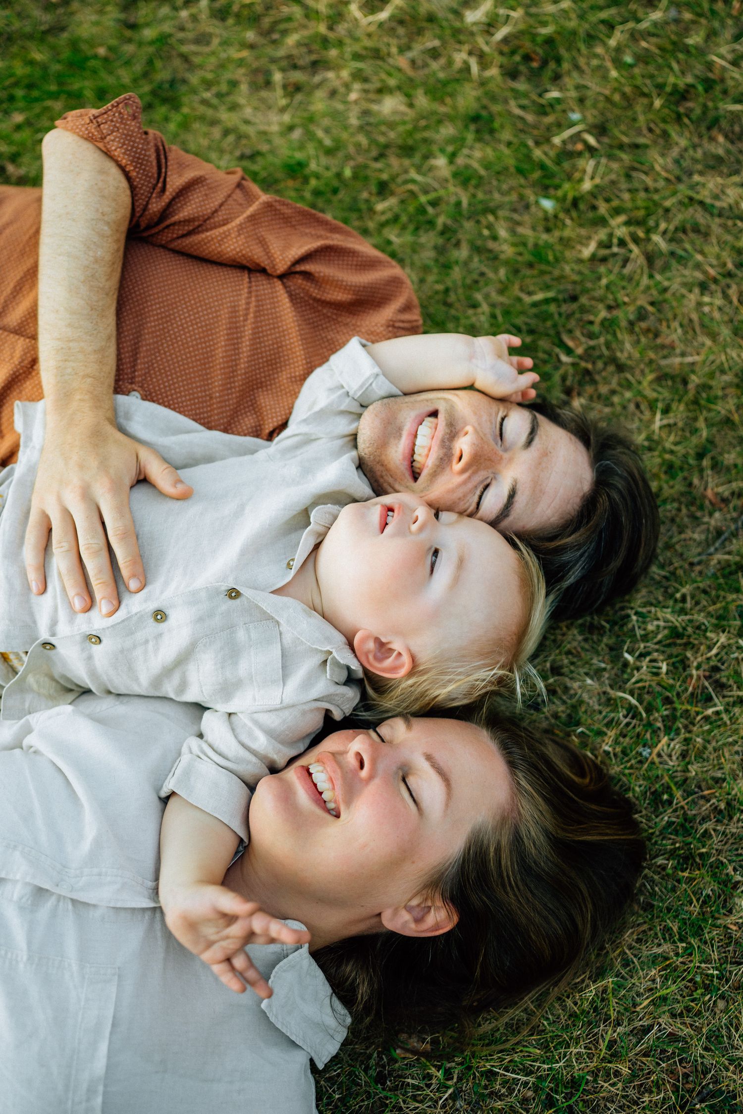 Familjen ligger på marken och kramas.