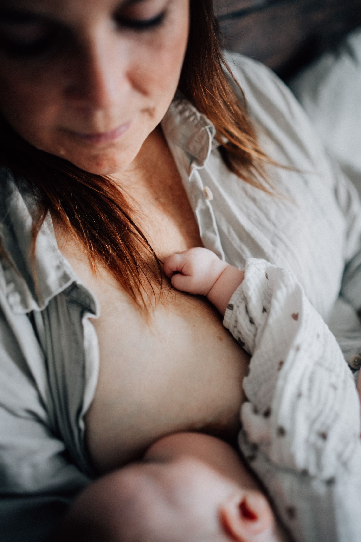 Bebisen ammas av sin mamma under nyföddfotograferingen i Östergötland.