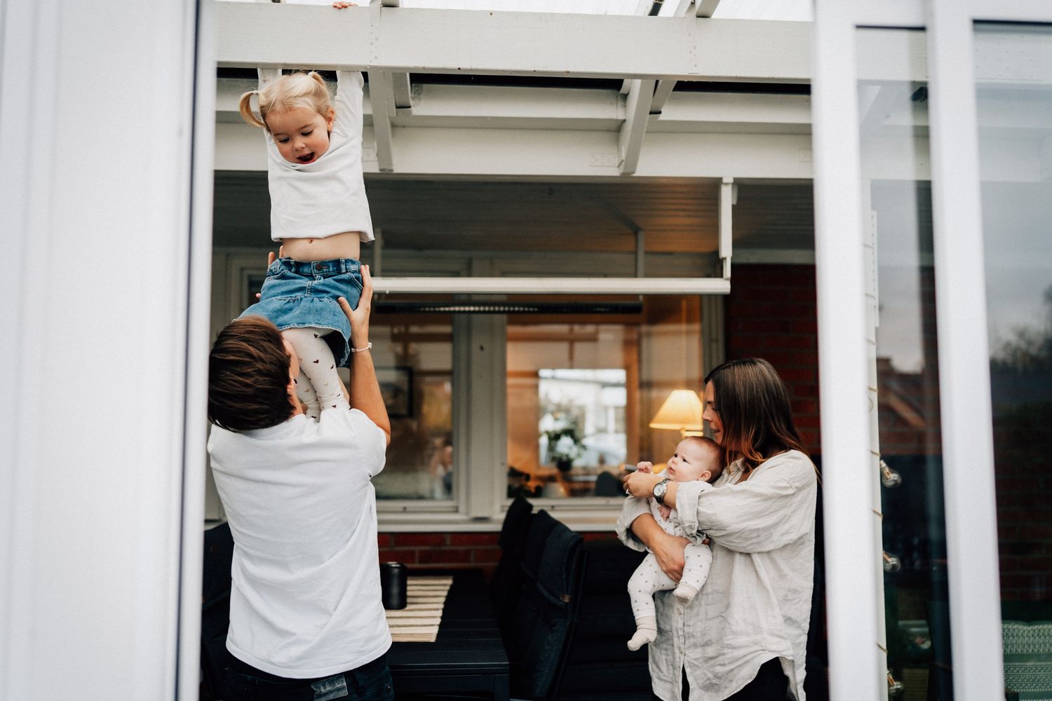 Två mammor busar med sina barn under familjefotograferingen i Linköping.