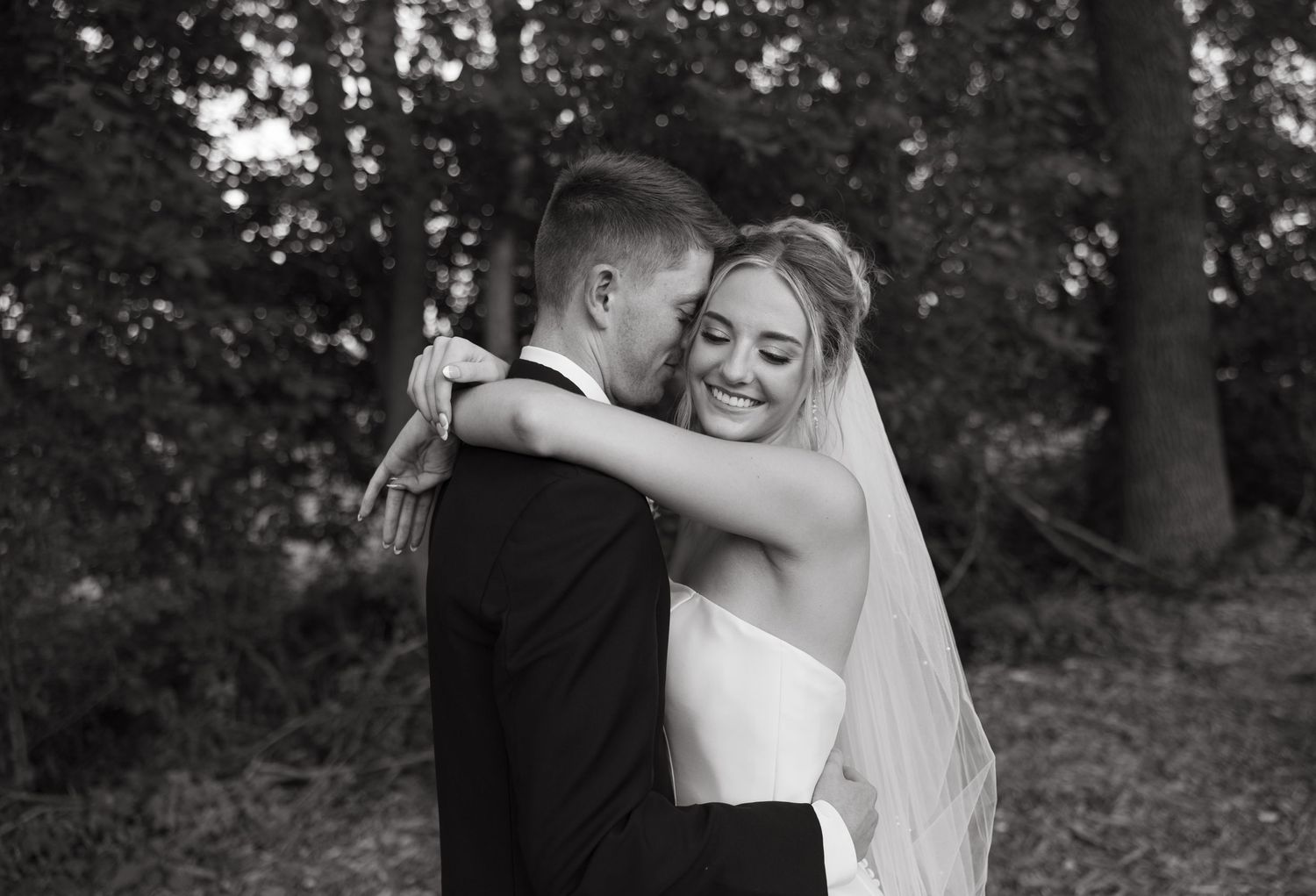 A black and white collage of wedding photos showing tender emotional moments between a bride and groom outdoors.