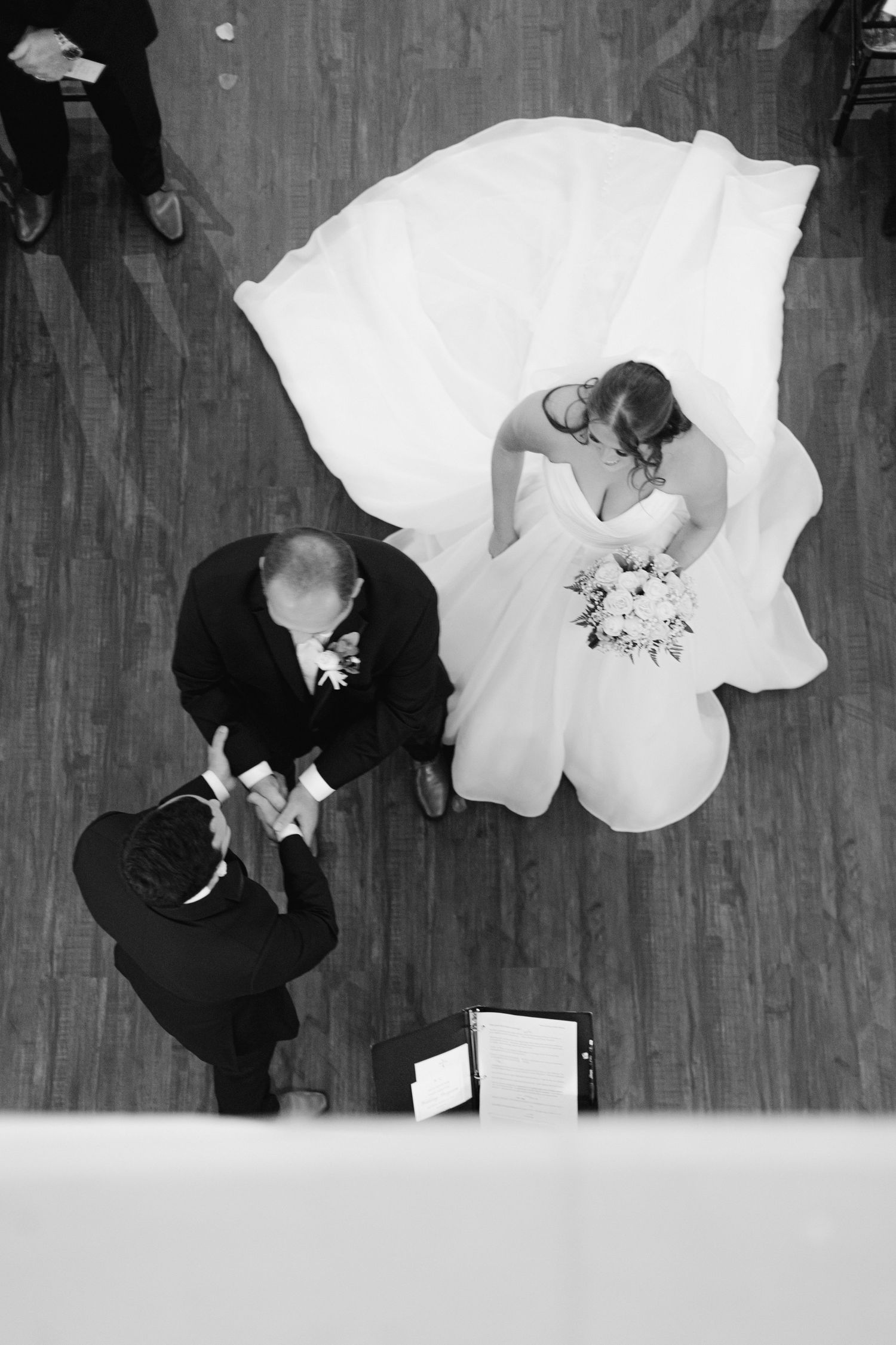 Black and white wedding dance sequence showing flowing white dress movement across wooden floor.