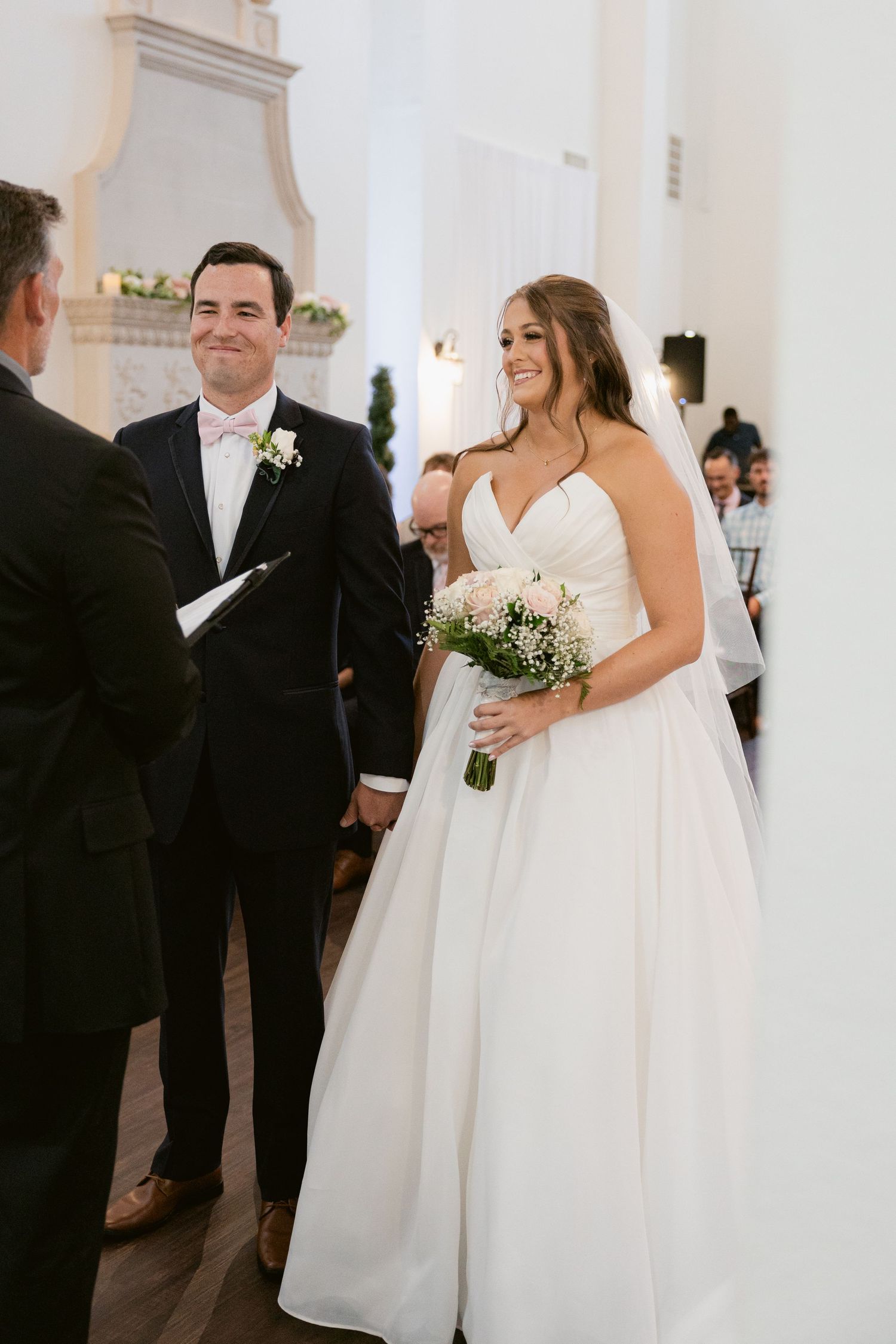Wedding ceremony moments captured in a white church interior with elegant decor and formal attire.