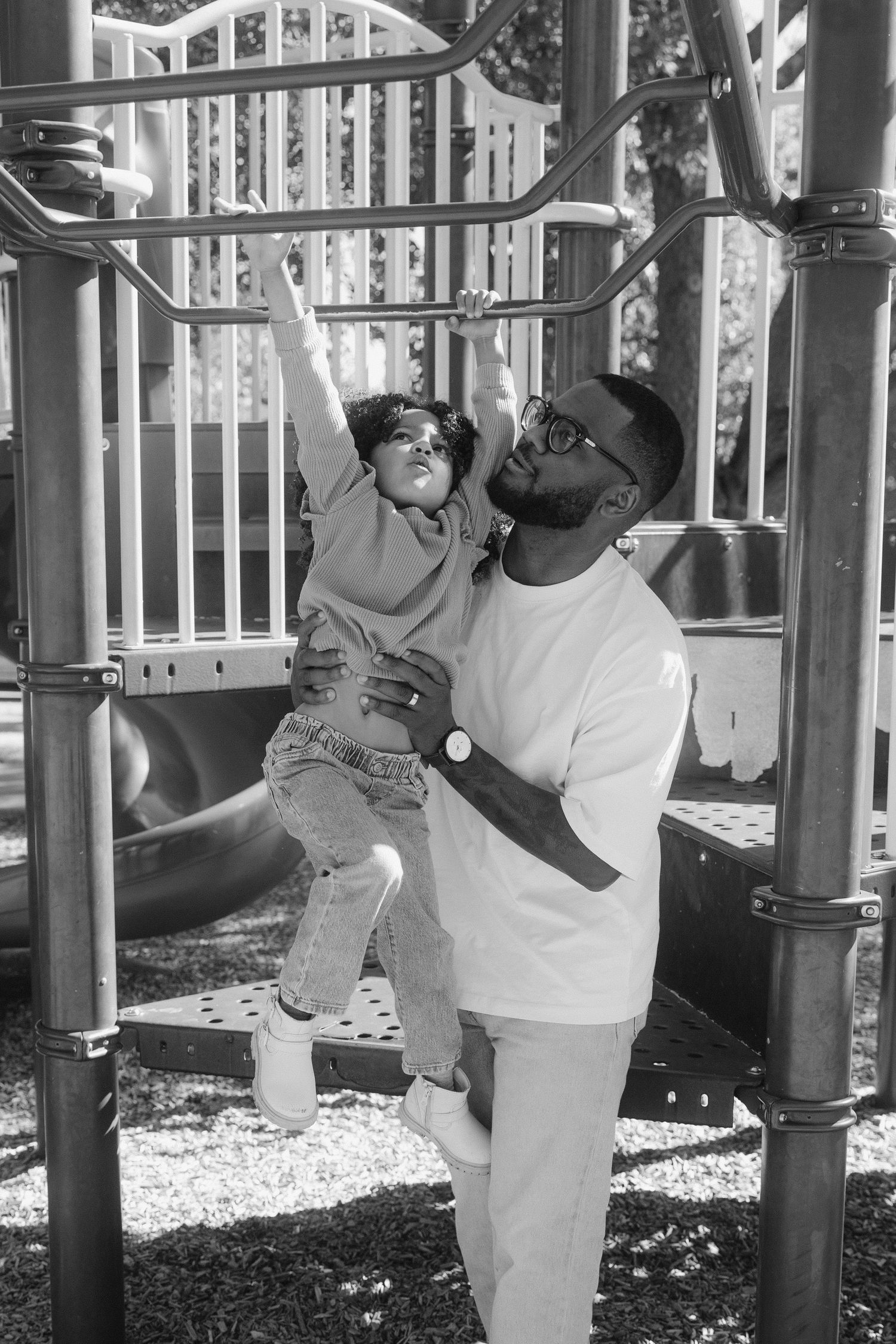 Black and white photos of people enjoying a playground with climbing equipment and playful poses.
