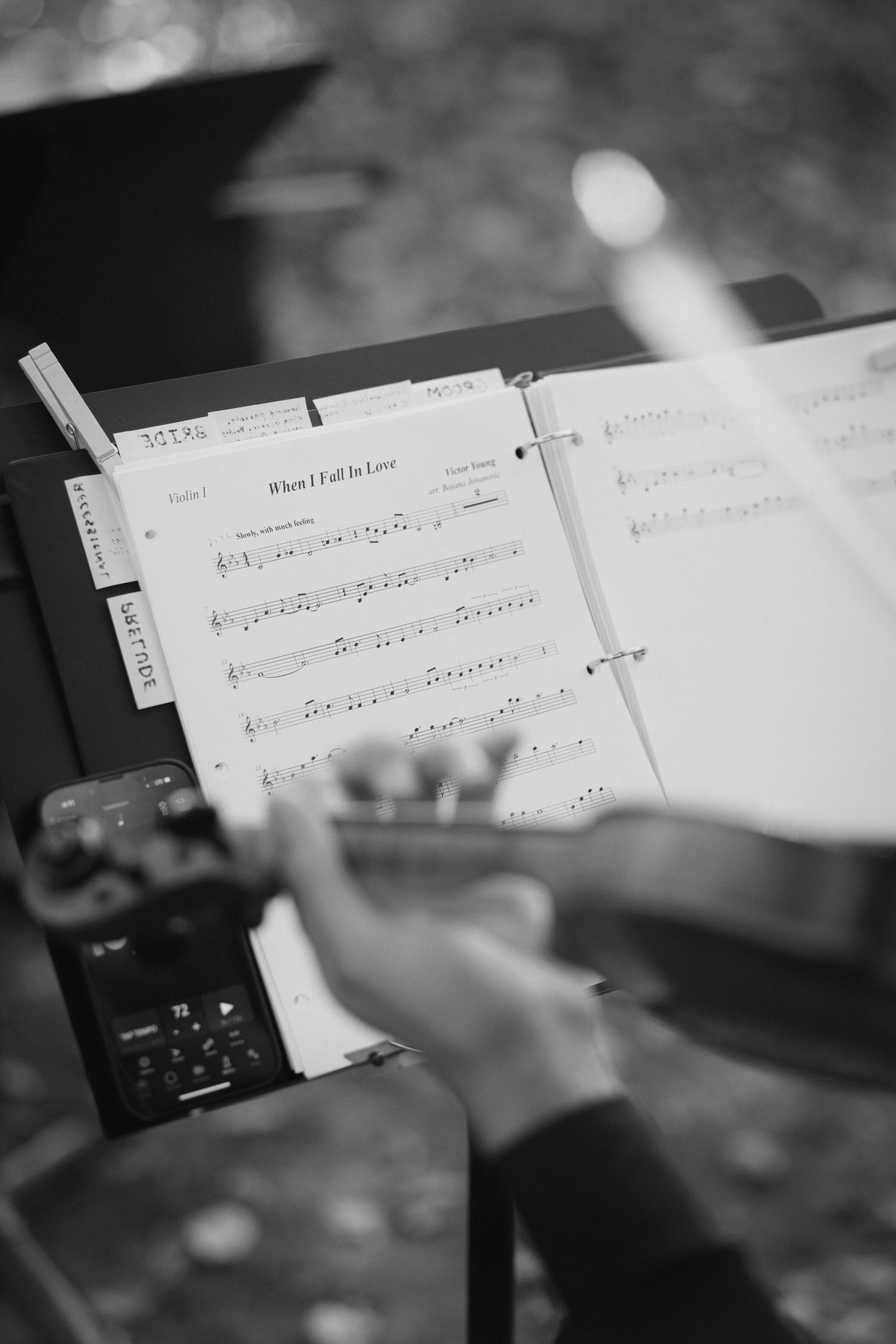 Sheet music on a music stand shown in black and white with blurred edges creating an artistic composition.