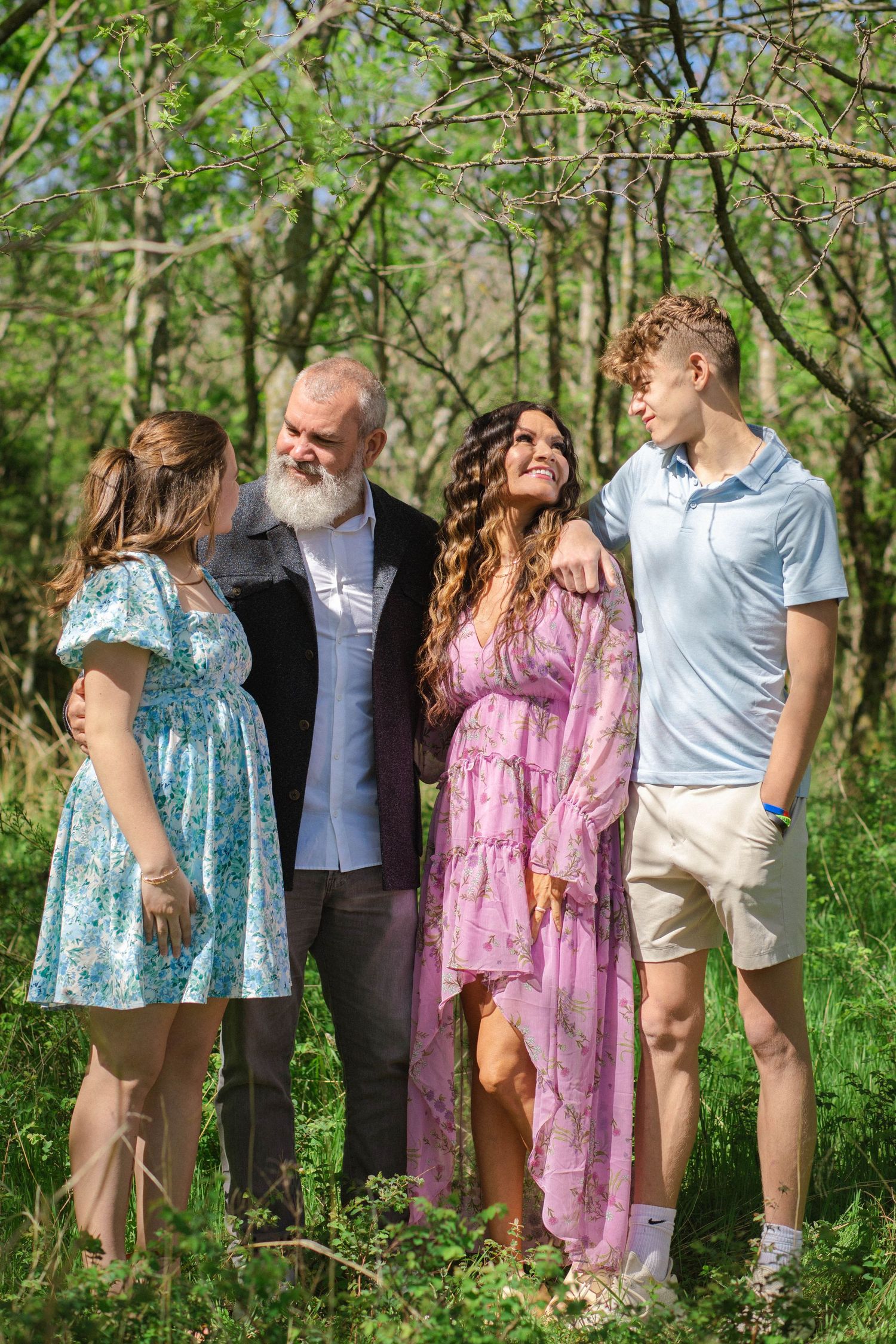 A series of five casual outdoor photos showing people posing together in a natural wooded setting during springtime.
