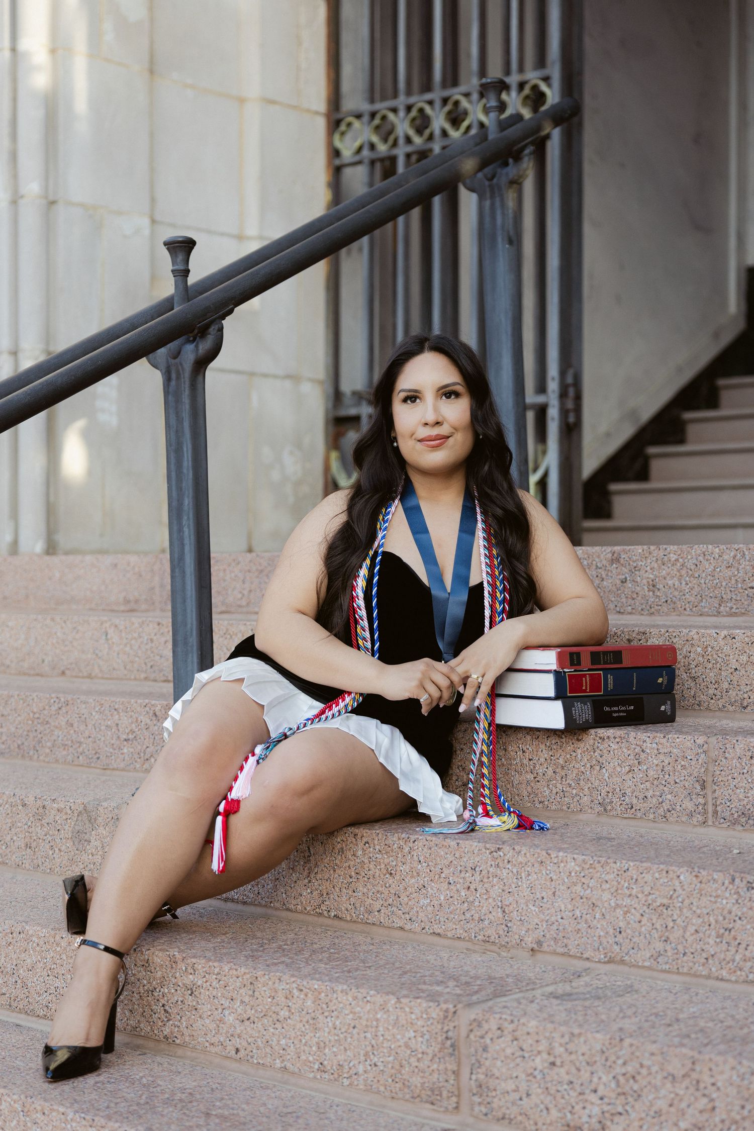 Woman in casual dress lounges on staircase steps in various relaxed poses with architectural backdrop.
