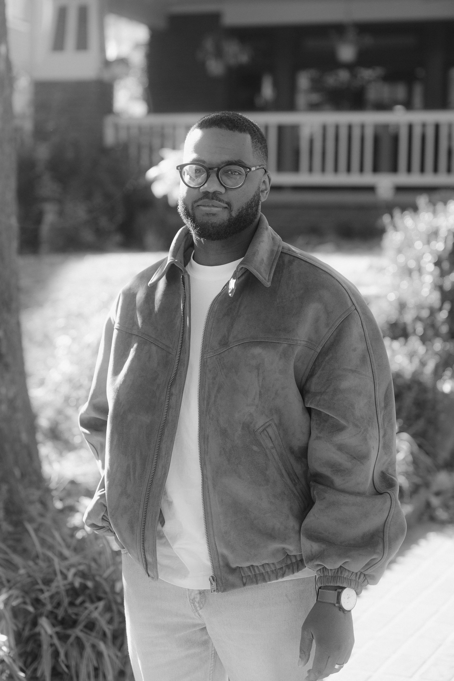 Black and white portrait series showing casual style with denim jacket and glasses in outdoor setting.