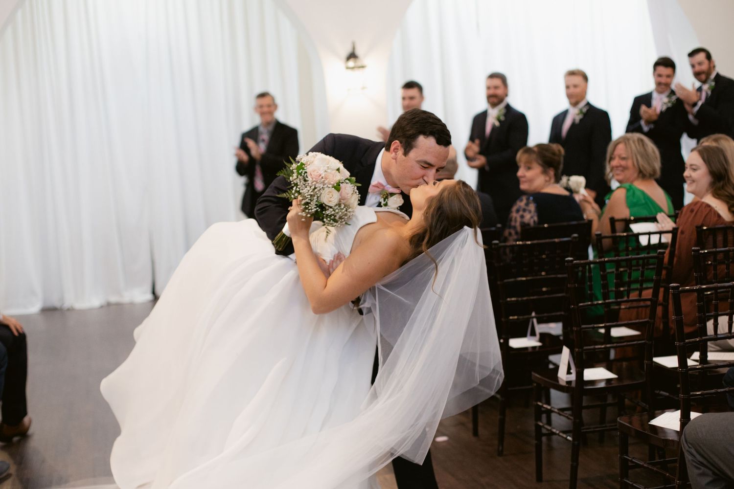 A wedding ceremony sequence showing emotional moments between the couple and guests in a white-draped venue.