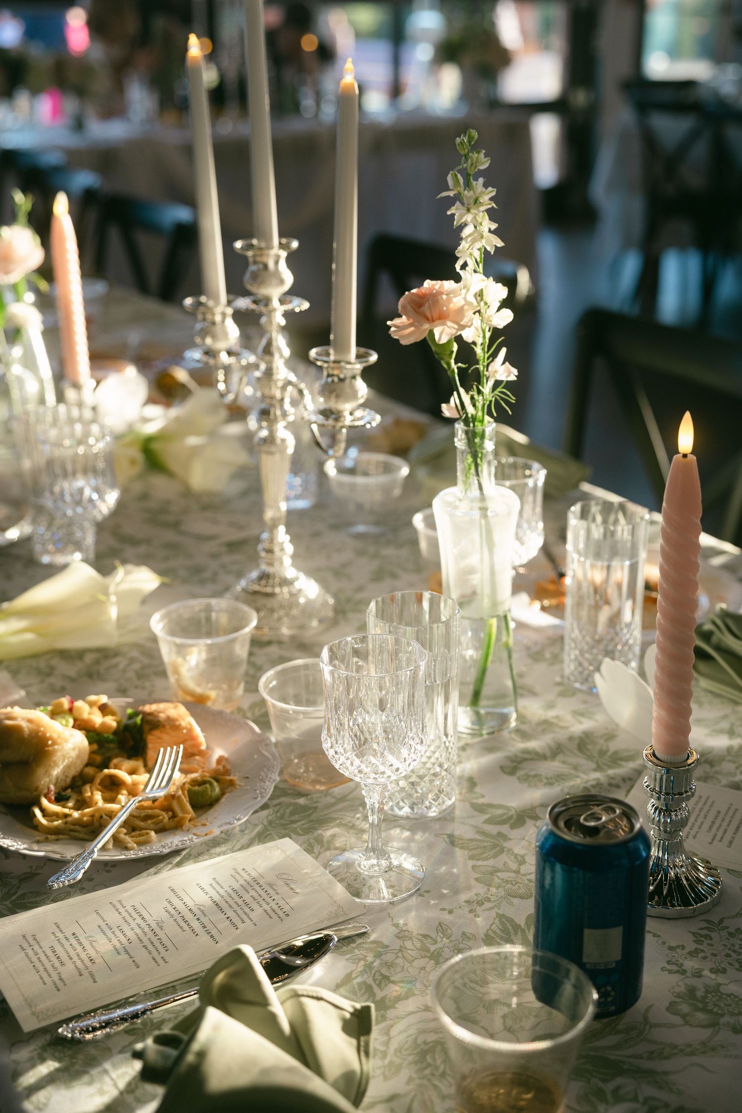 Elegant wedding reception table with crystal glasses, candles, and floral centerpieces.