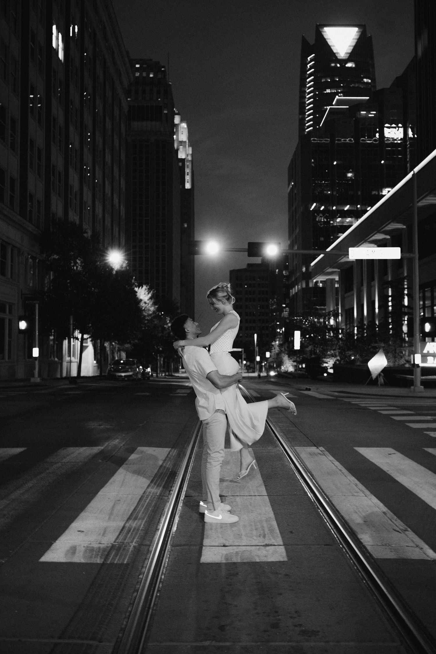 A series of black and white photos showing a dancer performing graceful movements on a dark city street at night.