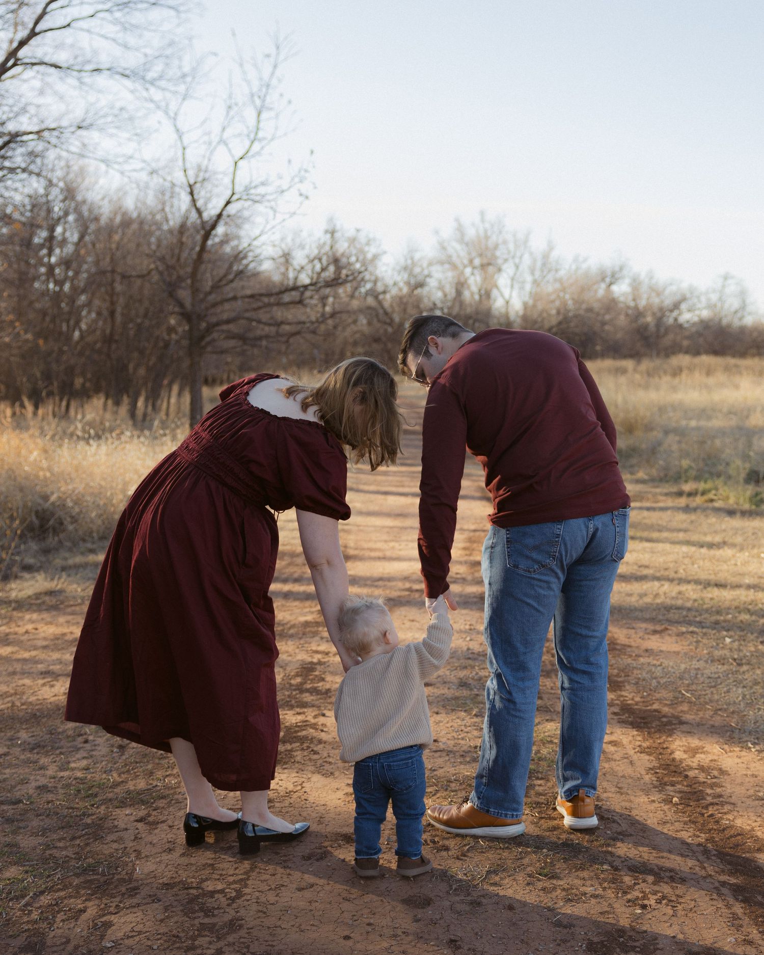A sequence of photos showing someone helping a small child walk along a dirt path on a winter afternoon.