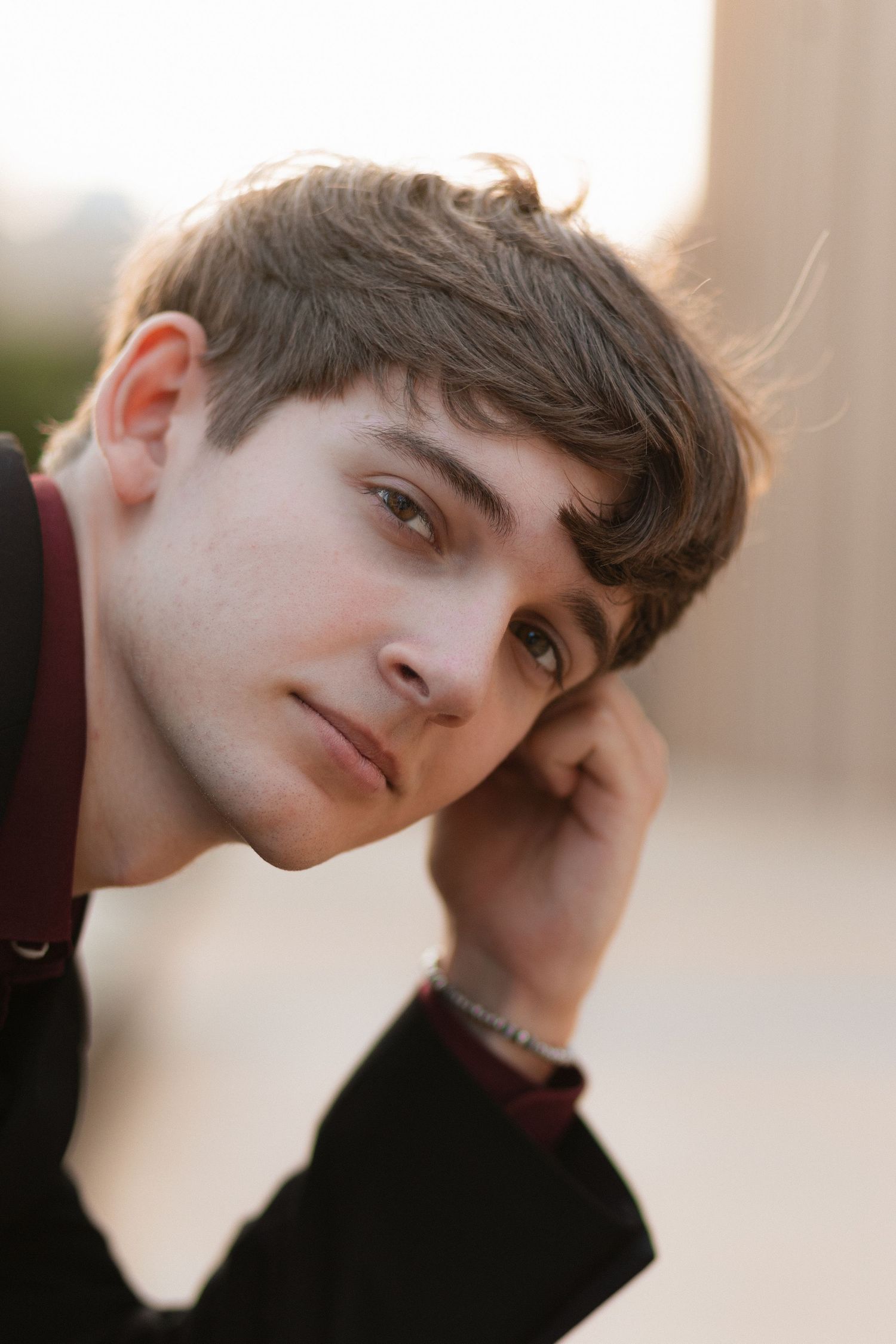 Portrait of someone with dark brown hair in a black sweater during golden hour lighting.