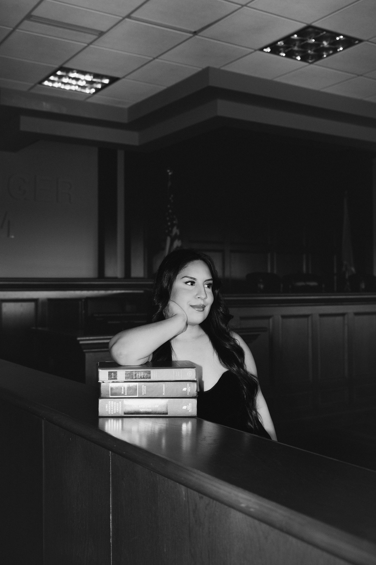 A black and white artistic sequence showing books resting on a dark wooden surface with dramatic lighting and shadows.