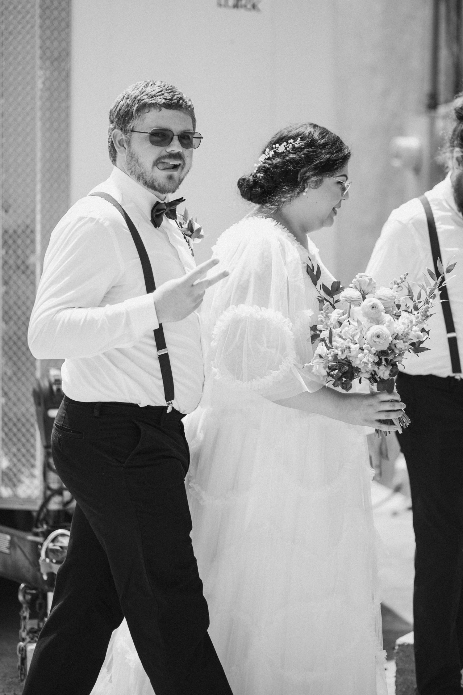 Black and white photo of wedding party members walking together in formal attire.