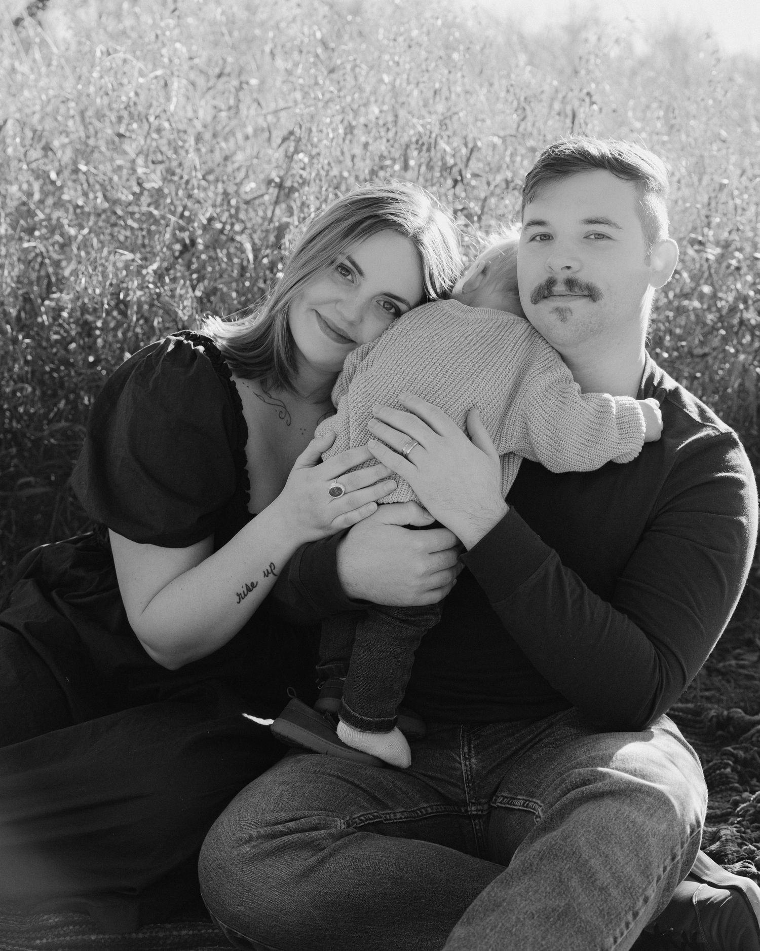 A playful black and white sequence showing two people embracing and laughing together in a sunny outdoor setting.